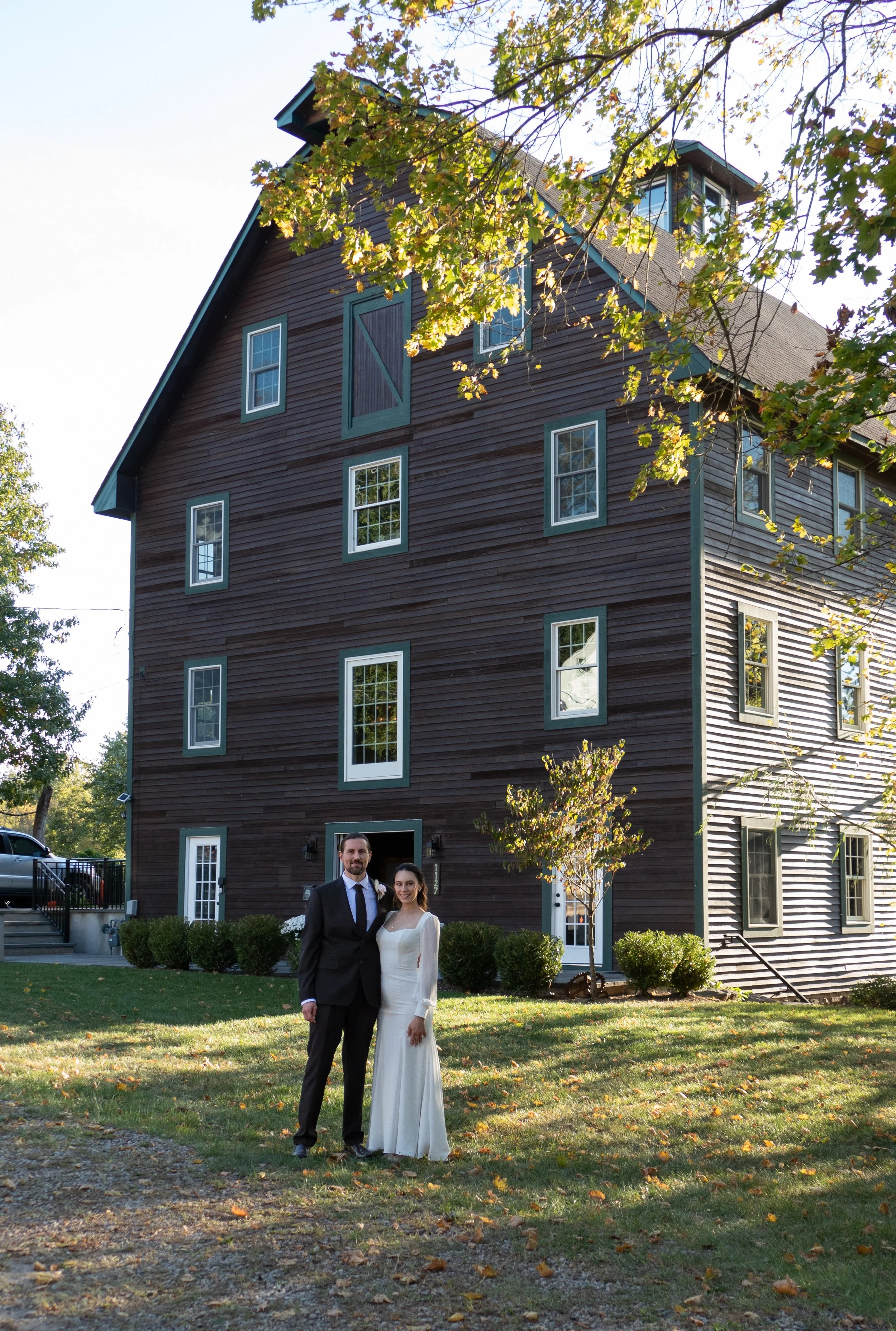 A bride and groom standing outside in front of their wedding event venue in Neshanic Station, NJ.