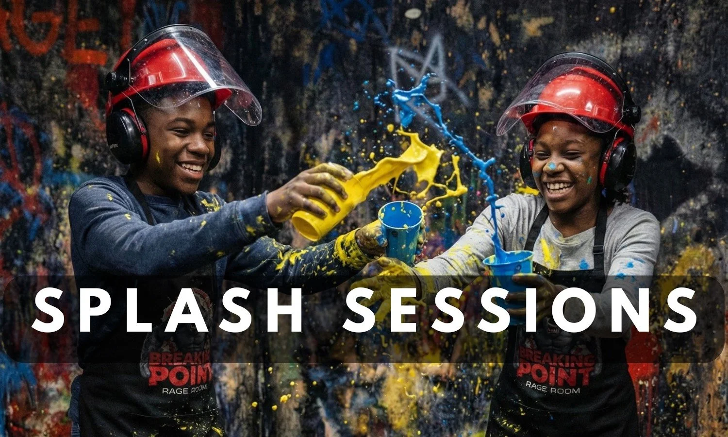 two young people laughing and throwing blue and yellow paint from cups in a splash room experience at Breaking Point Rage Room