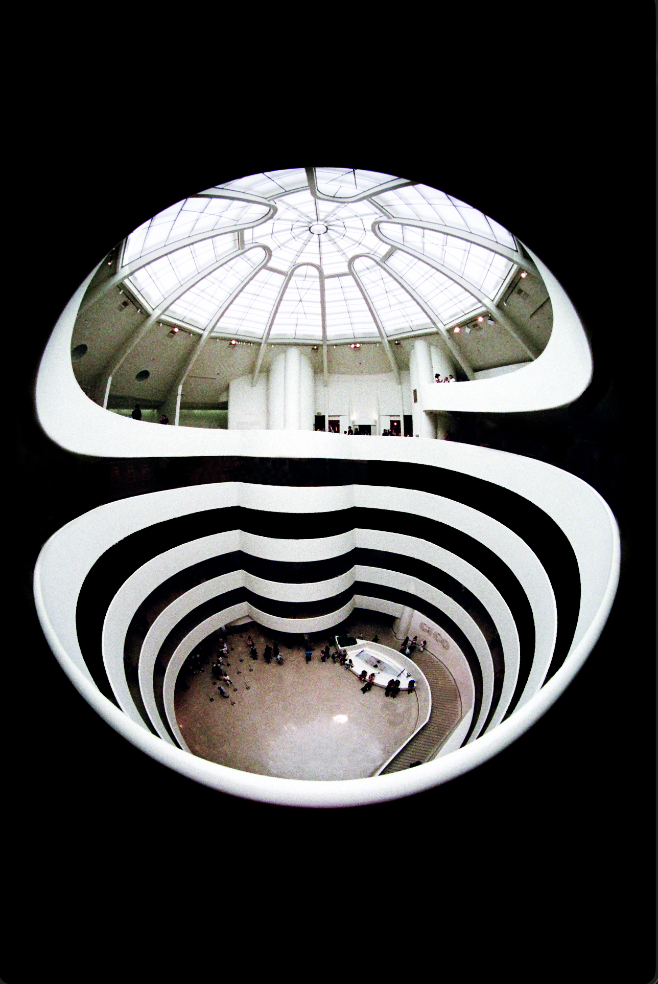 Interior view of a modern art museum with a spiral staircase and a large glass-domed ceiling.