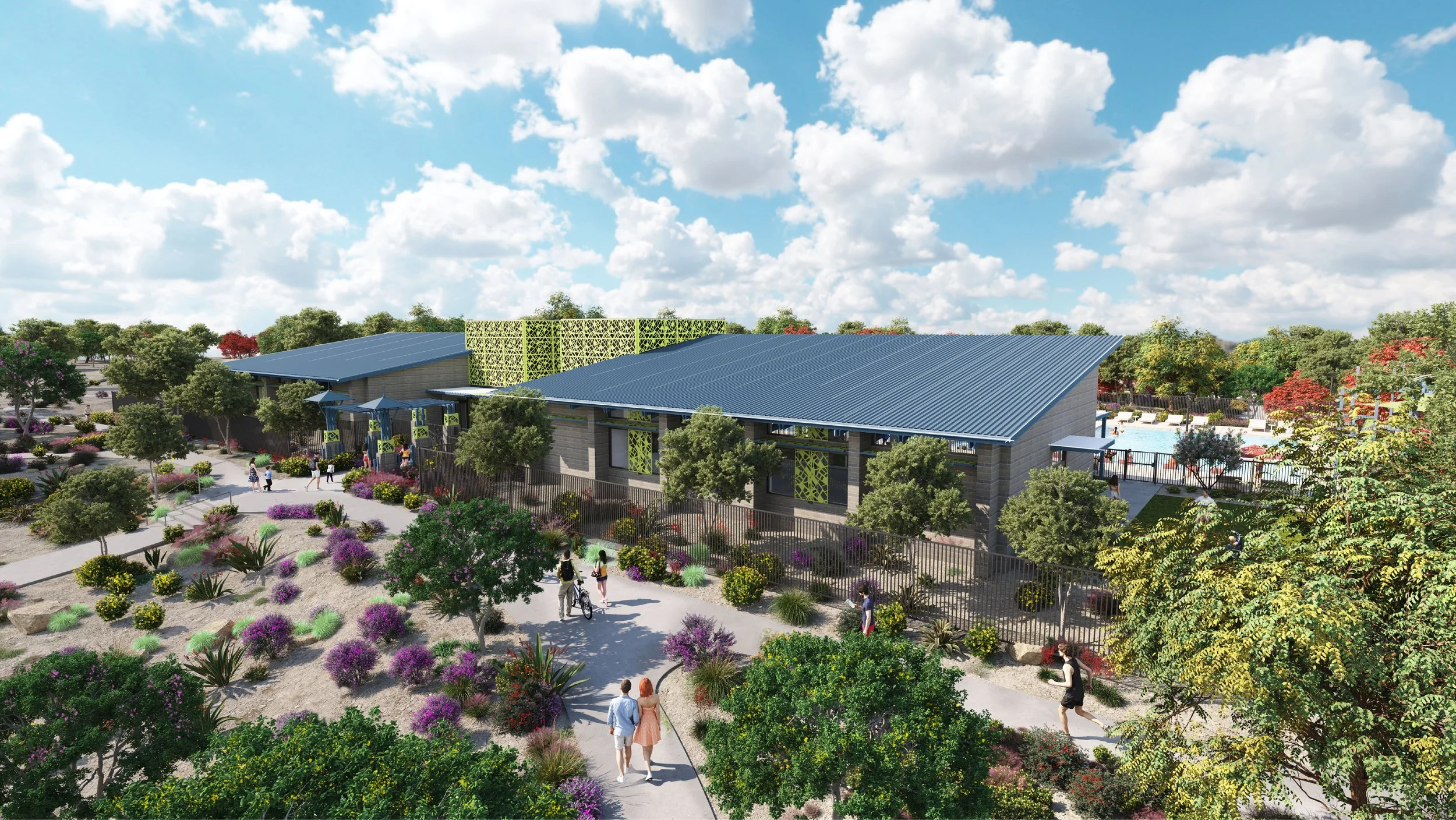 A community park with a modern building, walking paths, and various trees, shrubs, and flowering plants, under a partly cloudy sky.