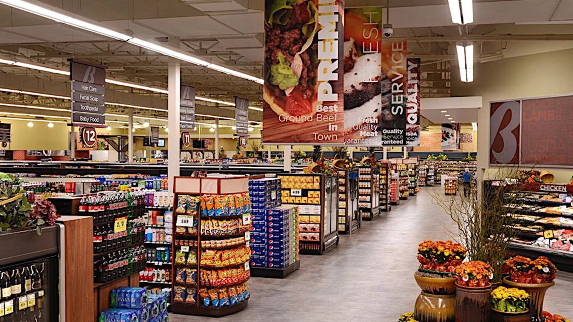Interior of a grocery store with aisles, signs, and shelves stocked with various products.
