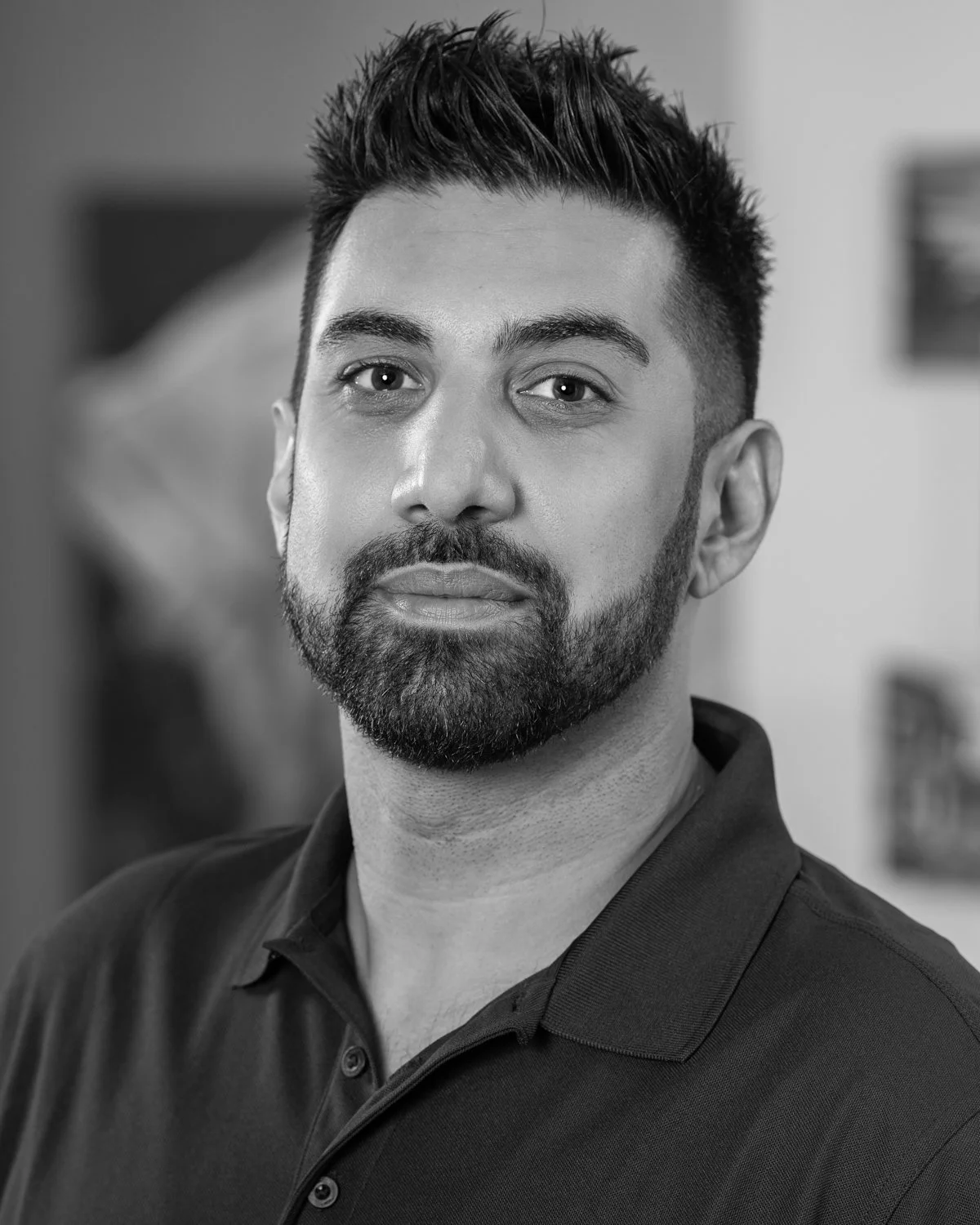 Black and white portrait of Rav Sandhu, Vice President of Construction at A.R. Mays Construction, wearing a collared shirt.