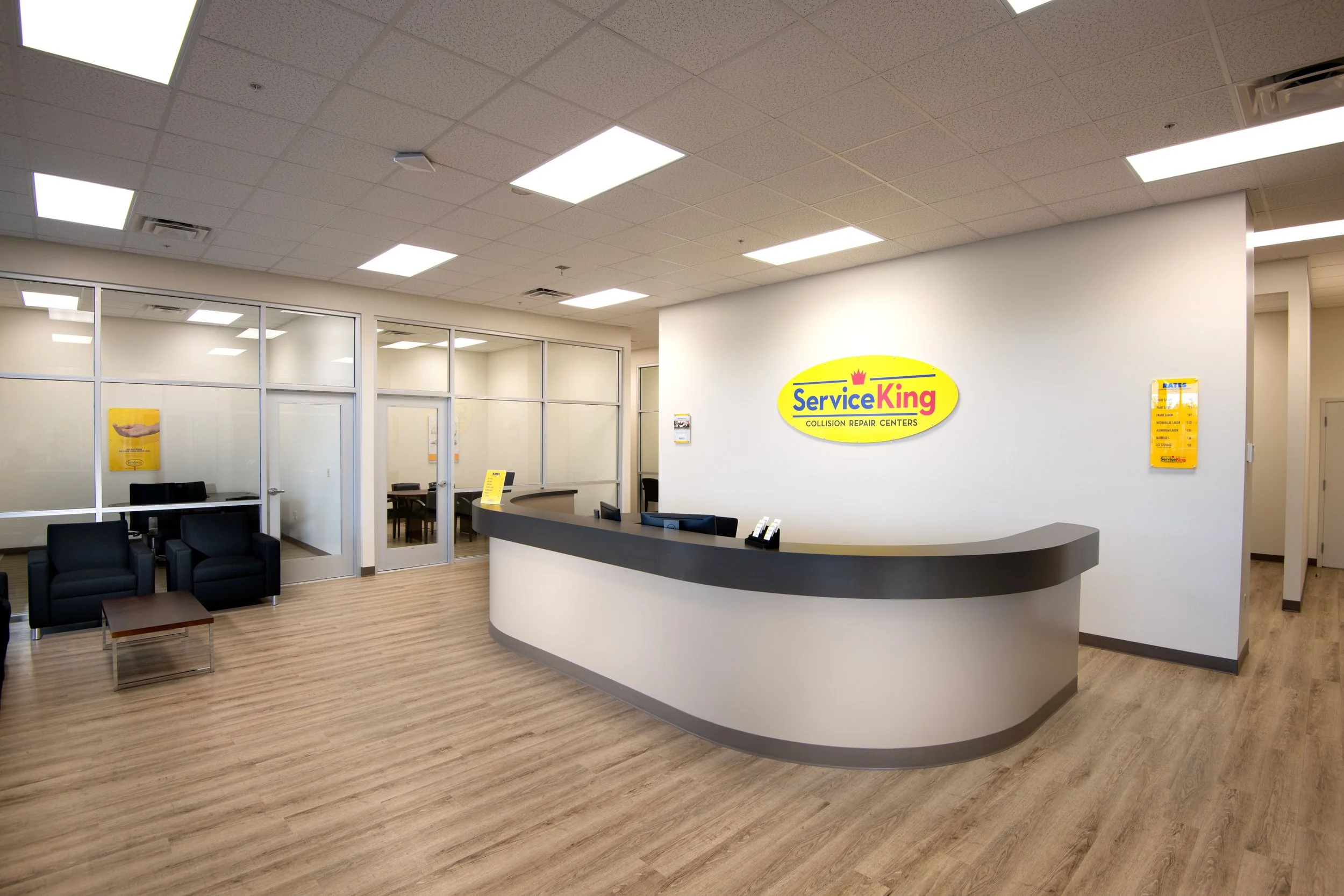 Interior of Service King collision repair center with reception desk, seating area, and glass-walled conference rooms.