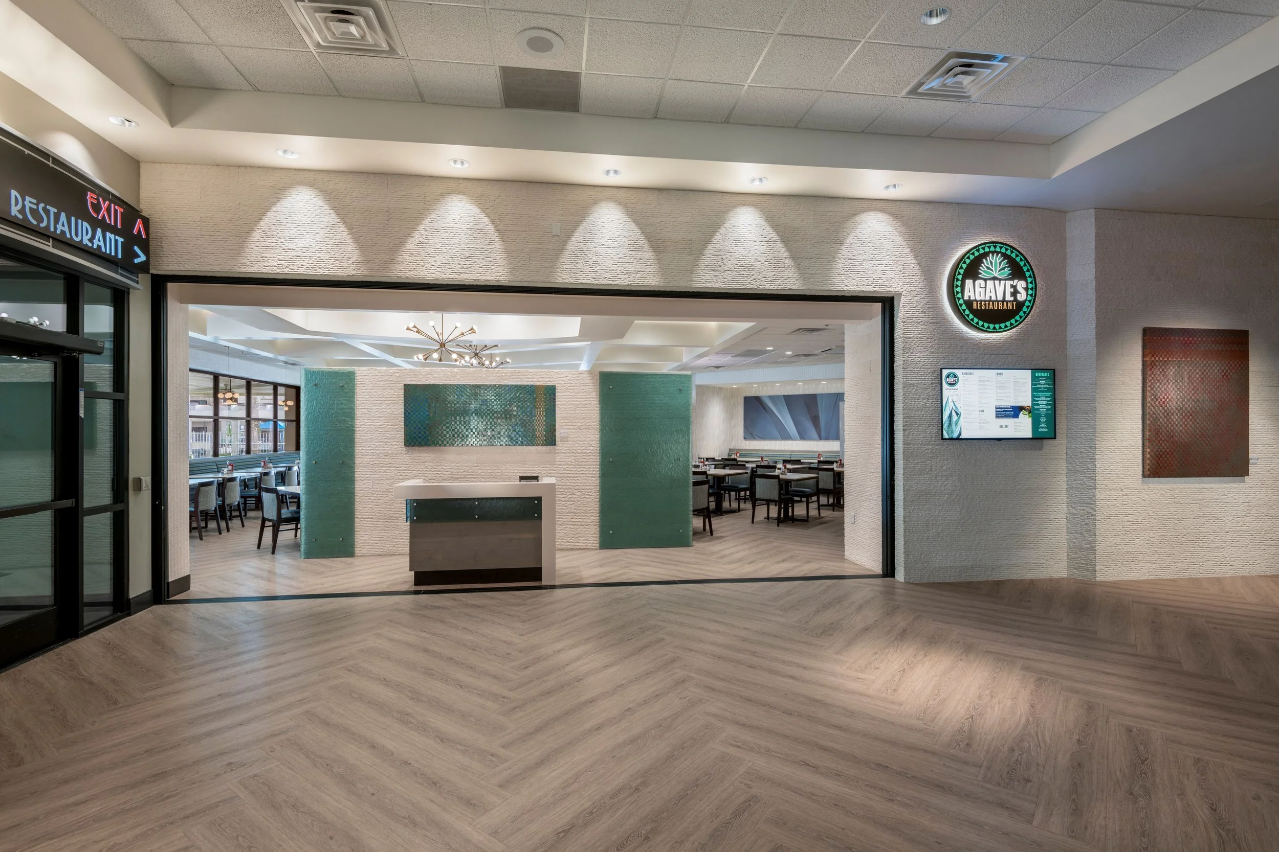 Entrance to Agave's Restaurant in a shopping mall with a digital menu display on the right side.