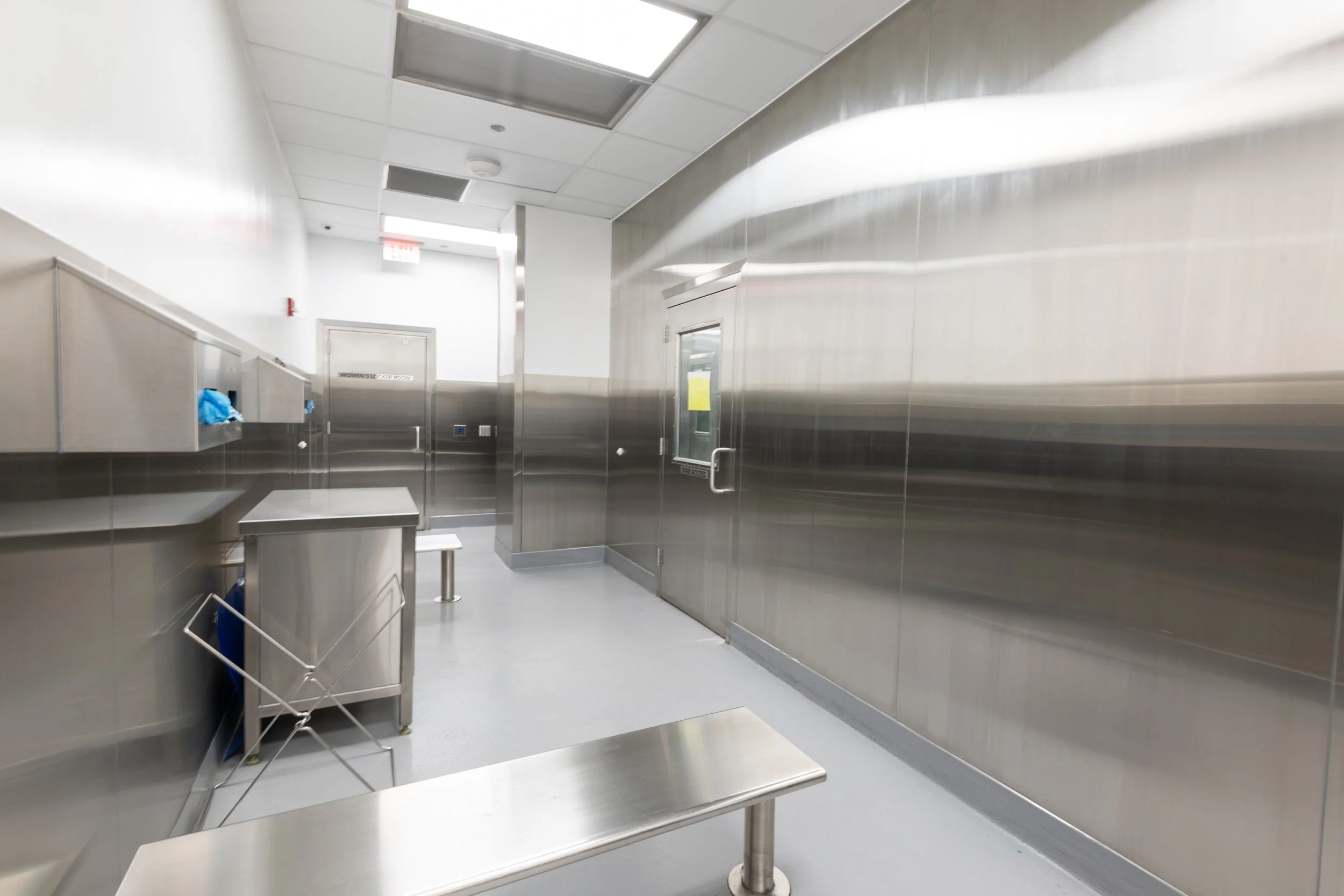 Sterile hospital room with stainless steel walls, equipment, and benches.