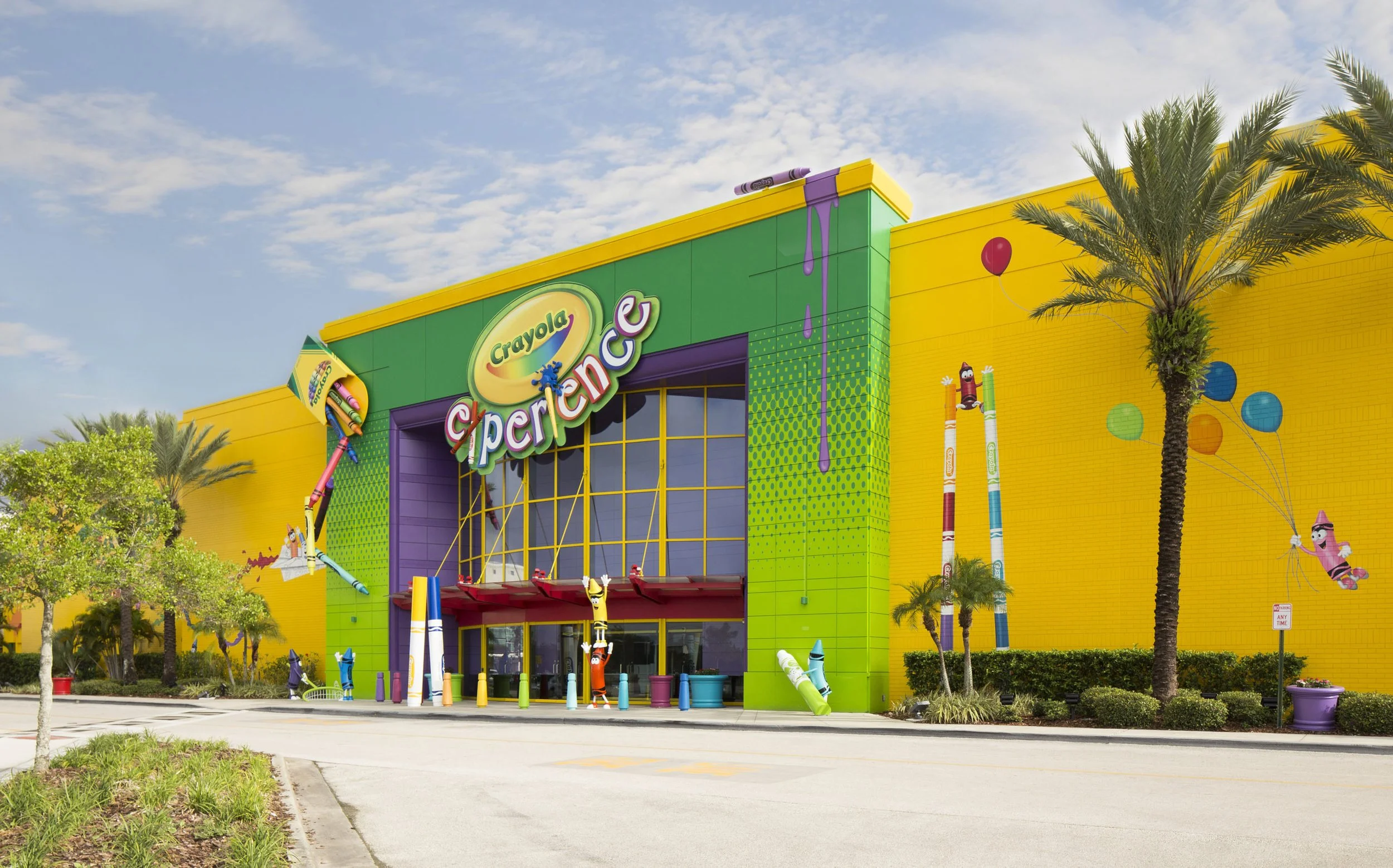 Colorful Crayola Store with yellow, green, and purple exterior, animated crayon characters on the walls, and a large sign reading 'Crayola superstore.'