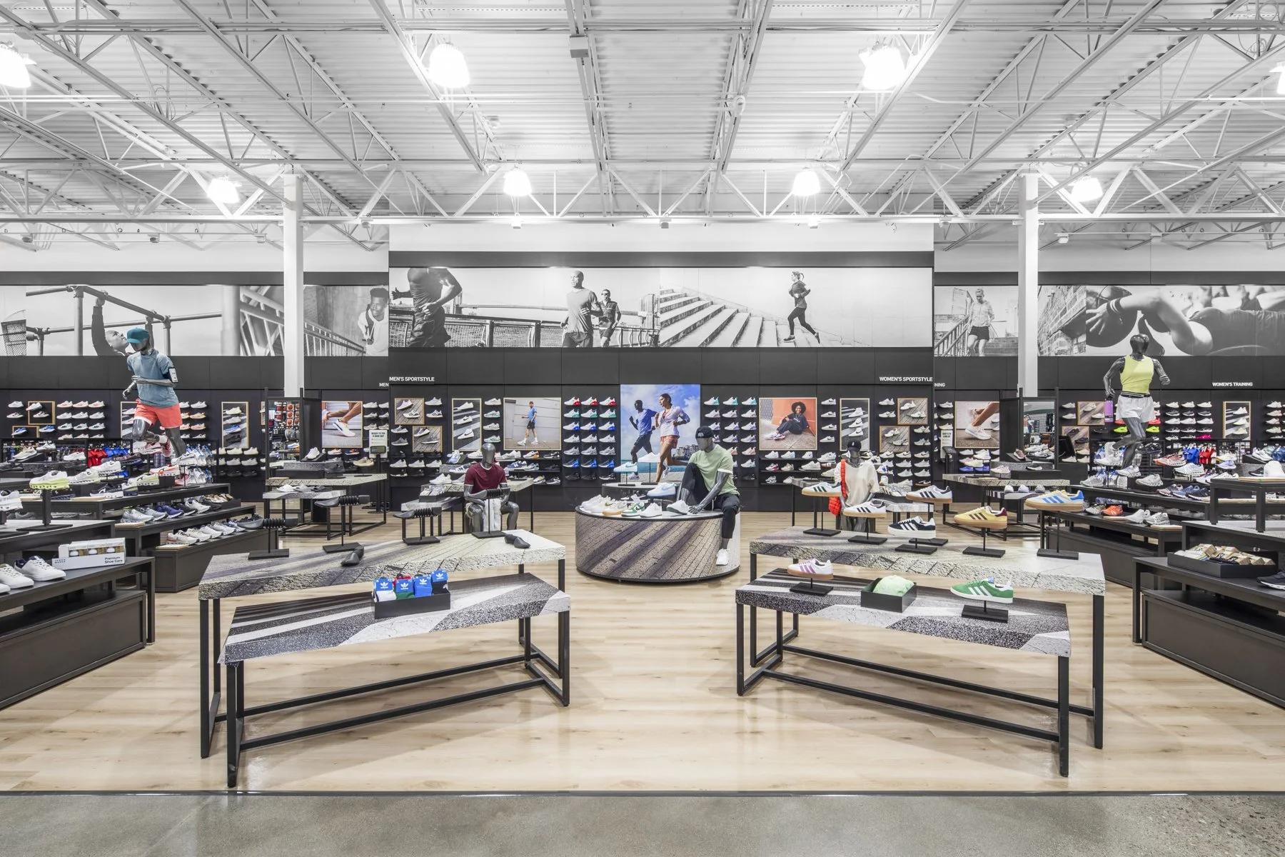 Interior of a sports footwear store with display shelves, mannequins, and posters of athletes.