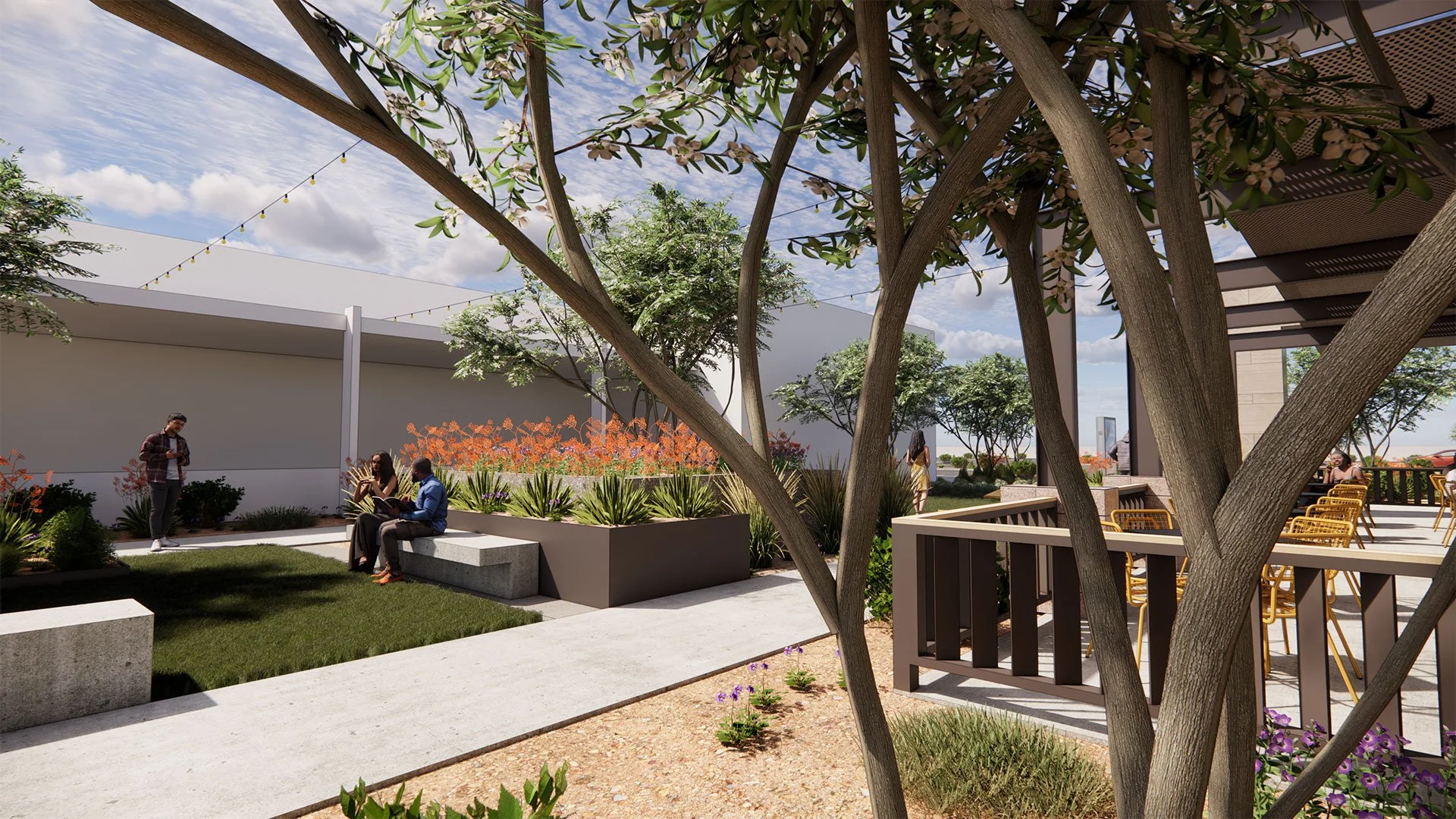 A landscaped outdoor patio area with trees, plants, and seating. People are sitting on benches and standing, enjoying the area under a partly cloudy sky with string lights overhead.