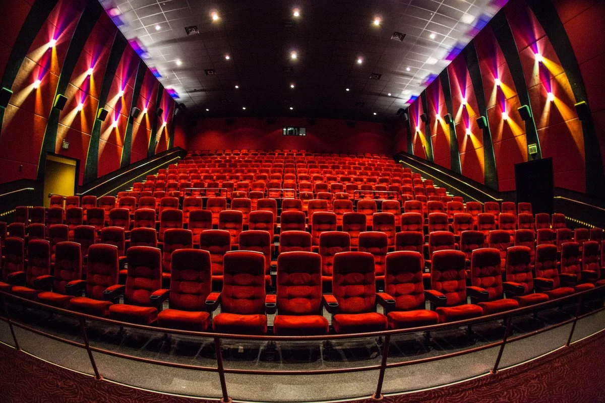 Theater with red seats and colorful light walls.