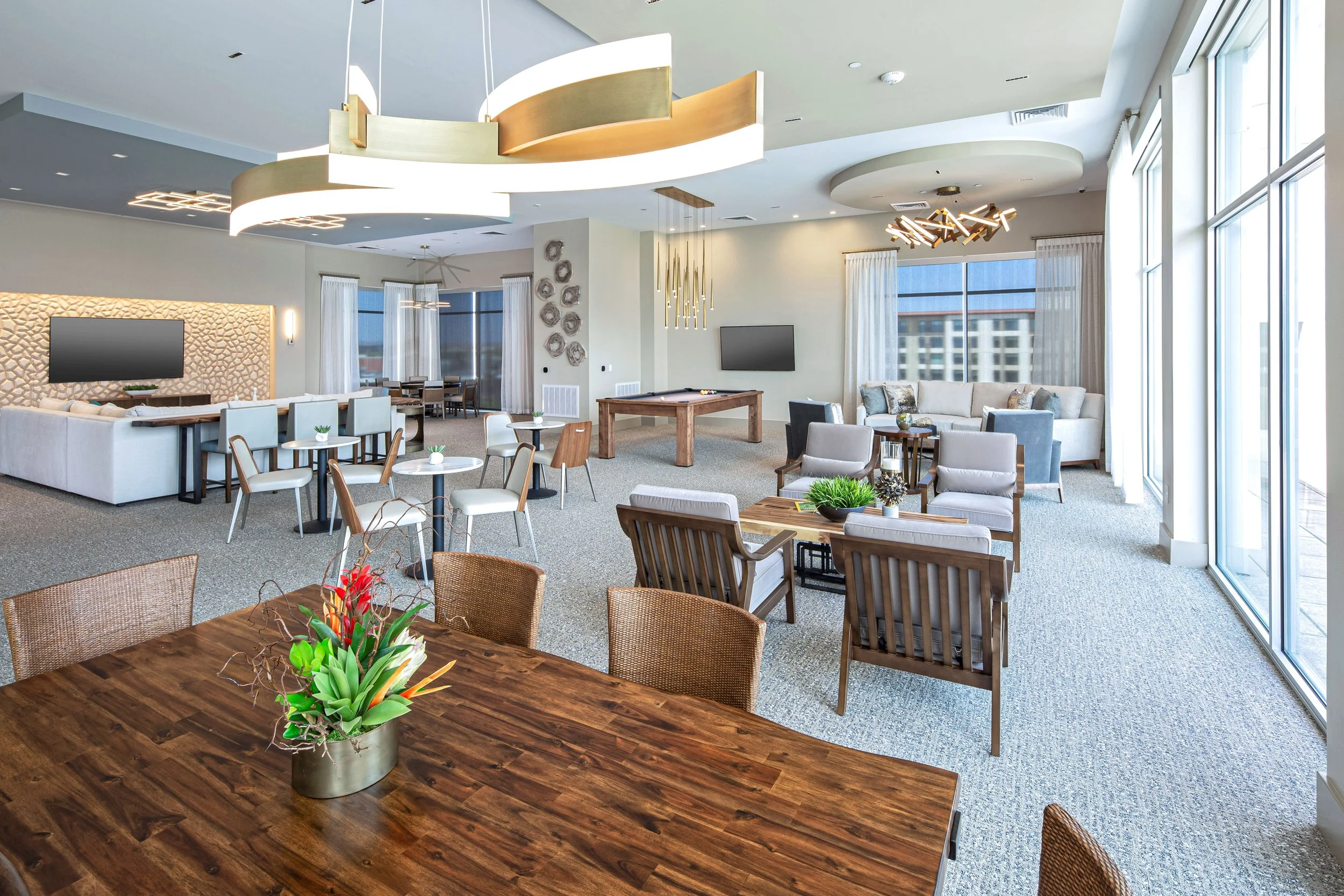 Spacious modern lounge area with various seating options, large windows, and contemporary decor.