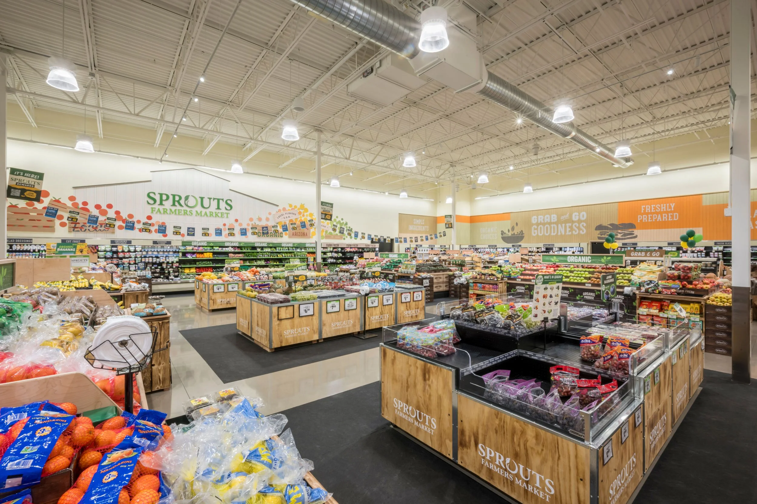 Interior of Sprouts Farmers Market grocery store with produce displays, signage, and bright lighting.