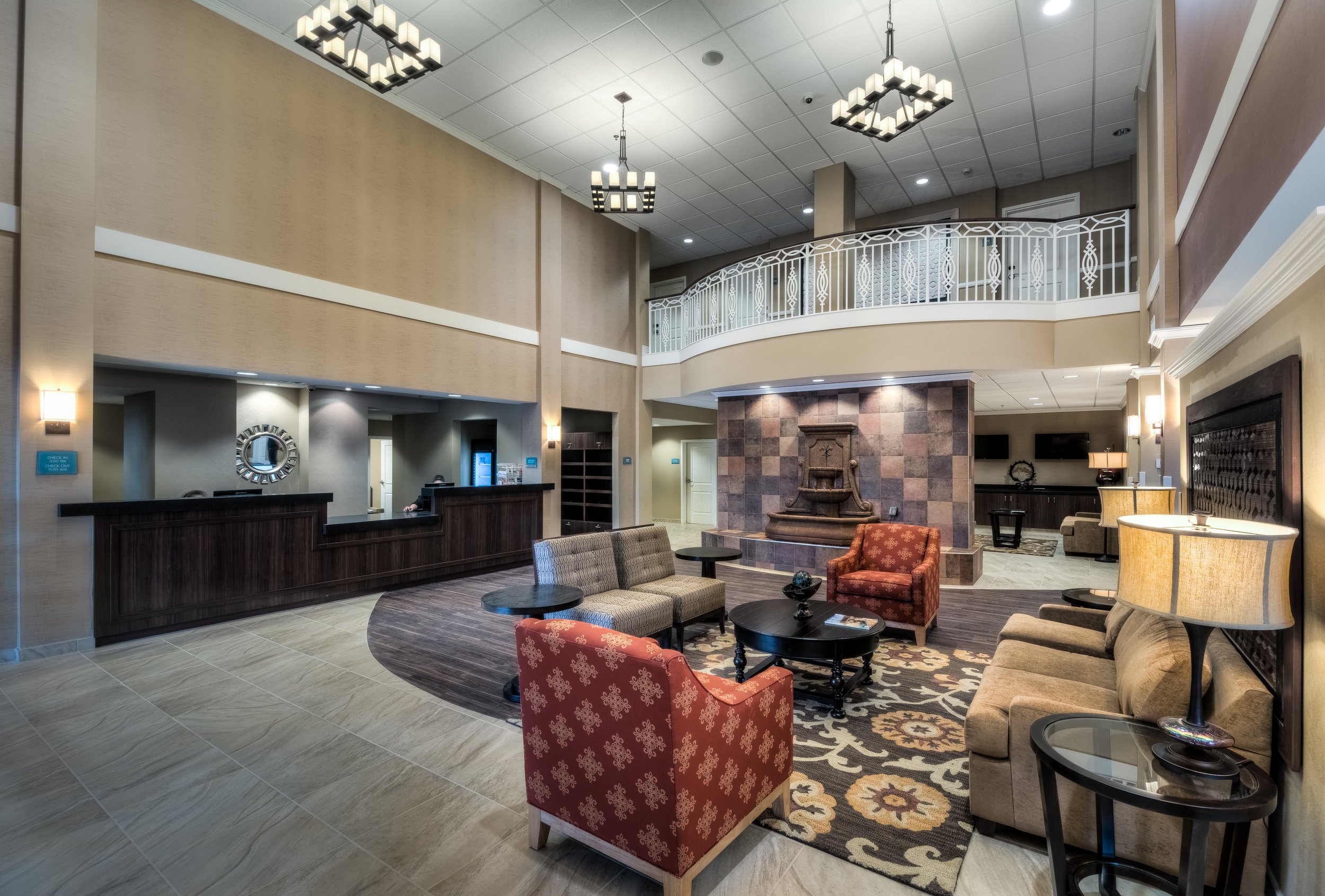 Lobby with seating area, fireplace, check-in counter, and decorative lighting fixtures.