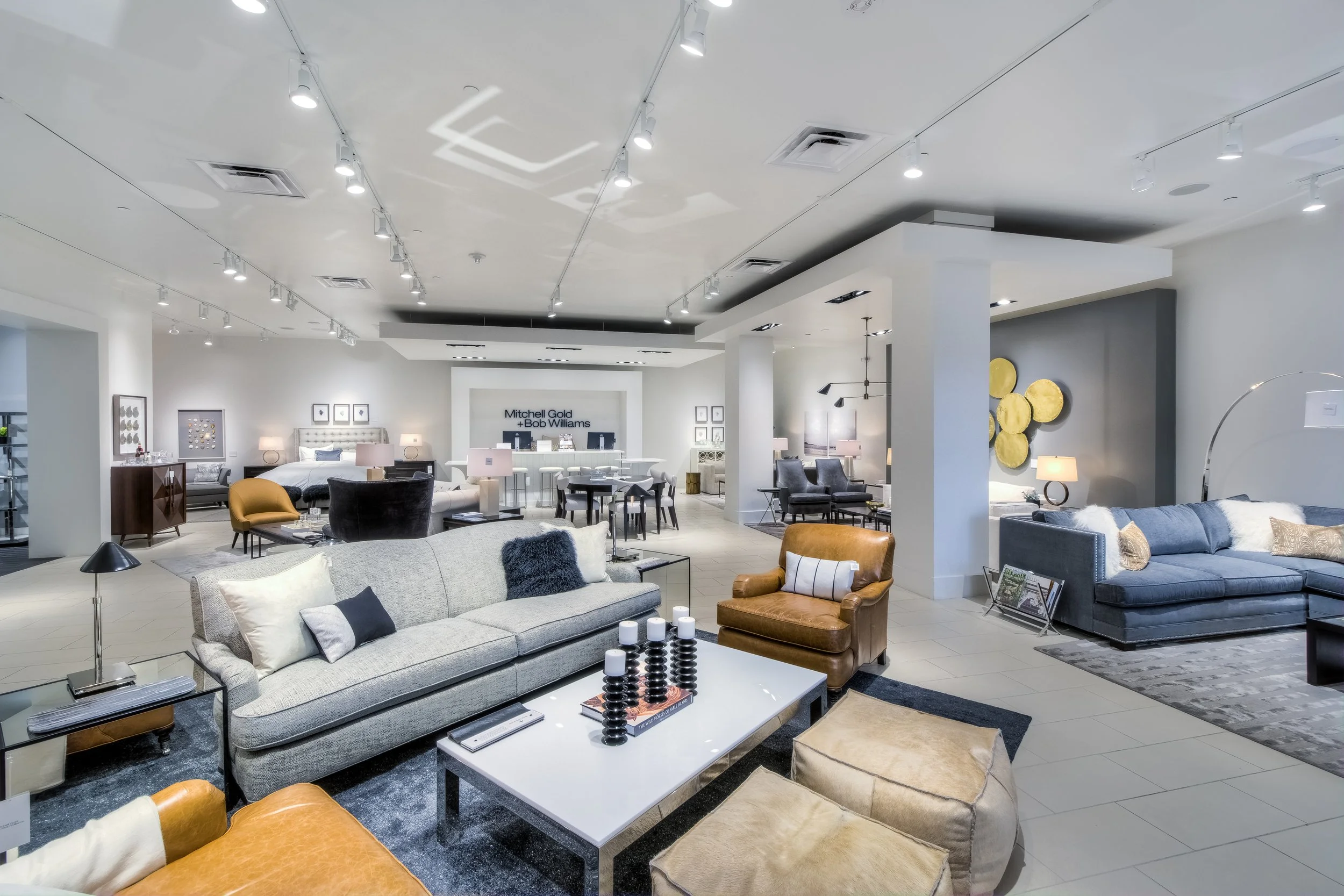 Interior of a modern furniture store with various sofas, chairs, tables, and decorative items on display.