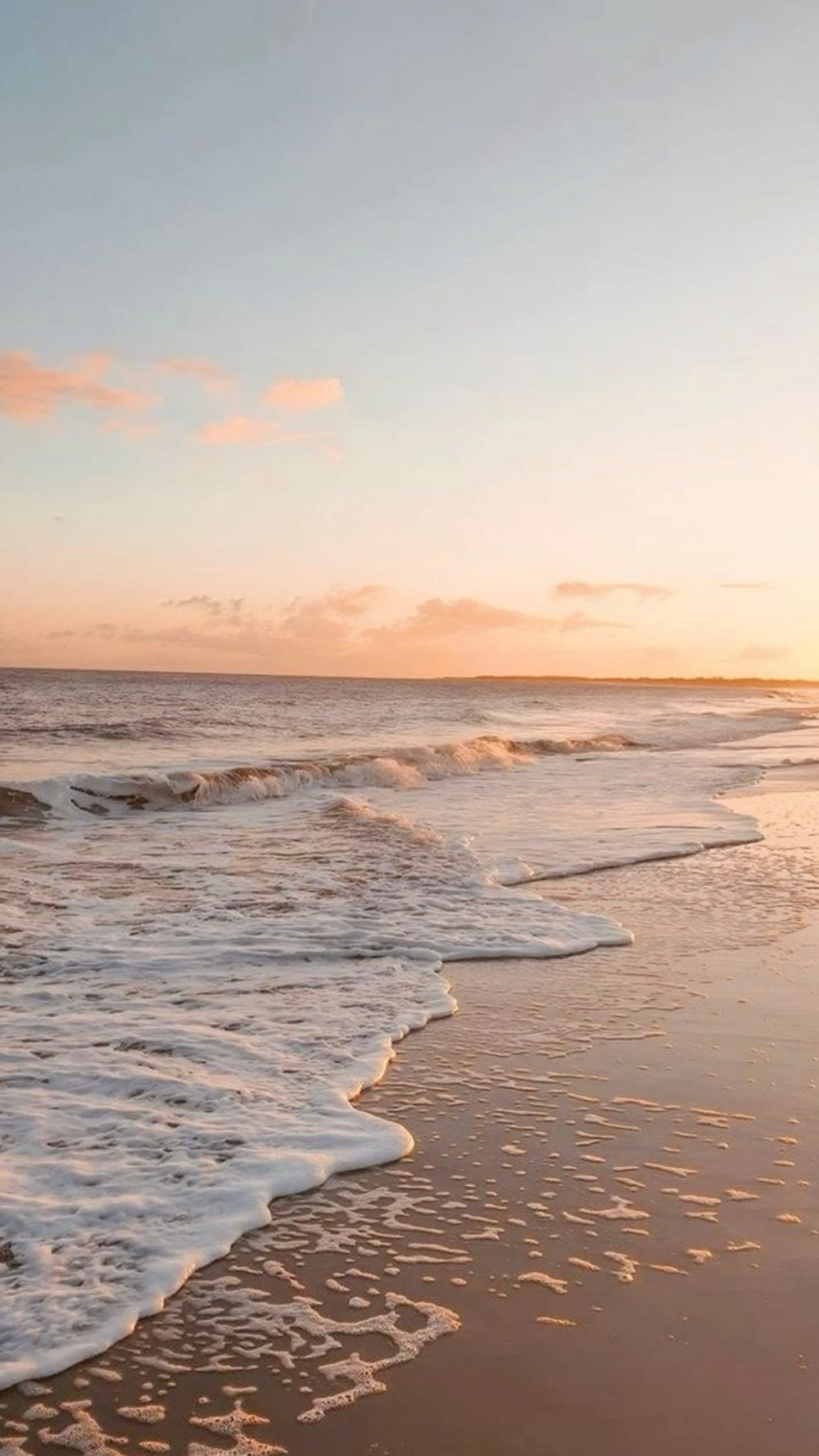 Plage au coucher du soleil avec des vagues et des nuages roses