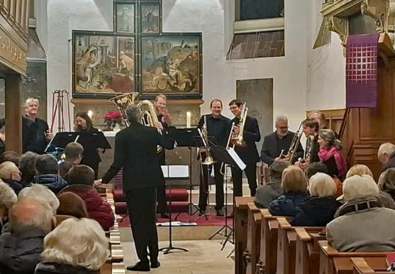 Ein Orchester spielt in einer Kirche vor einem Publikum.
