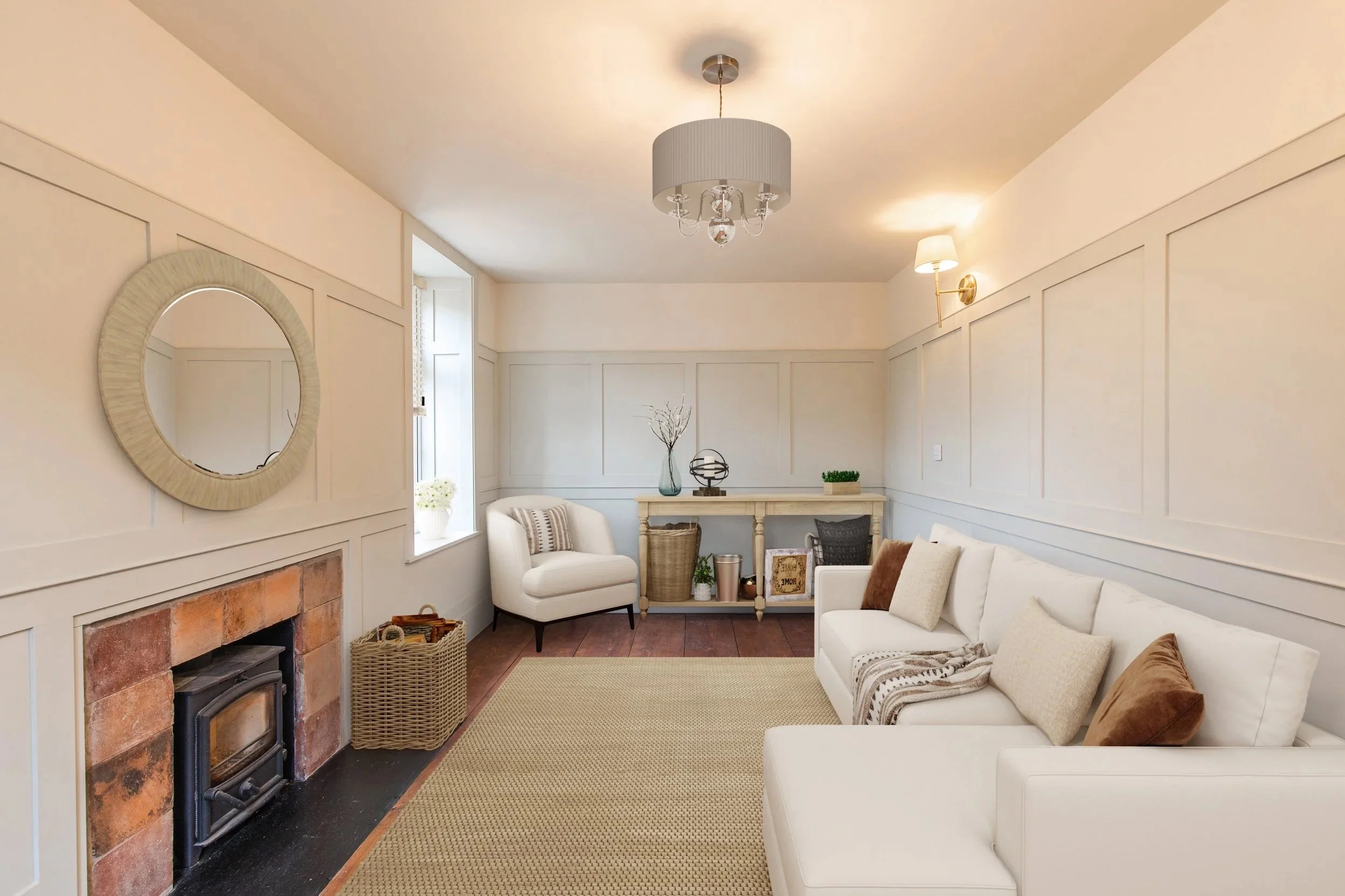 Living room with white sofa, armchair, fireplace, wooden floor, window with white curtains, beige walls, decorative items, and ceiling lights.
