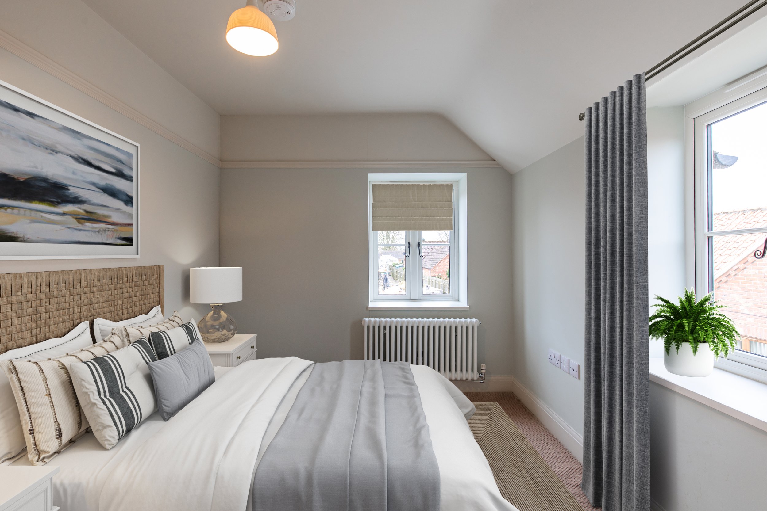 Well-lit bedroom with a bed covered in white and gray bedding, a wooden headboard, a white nightstand with a lamp, a window with blinds, and a potted fern on the windowsill.