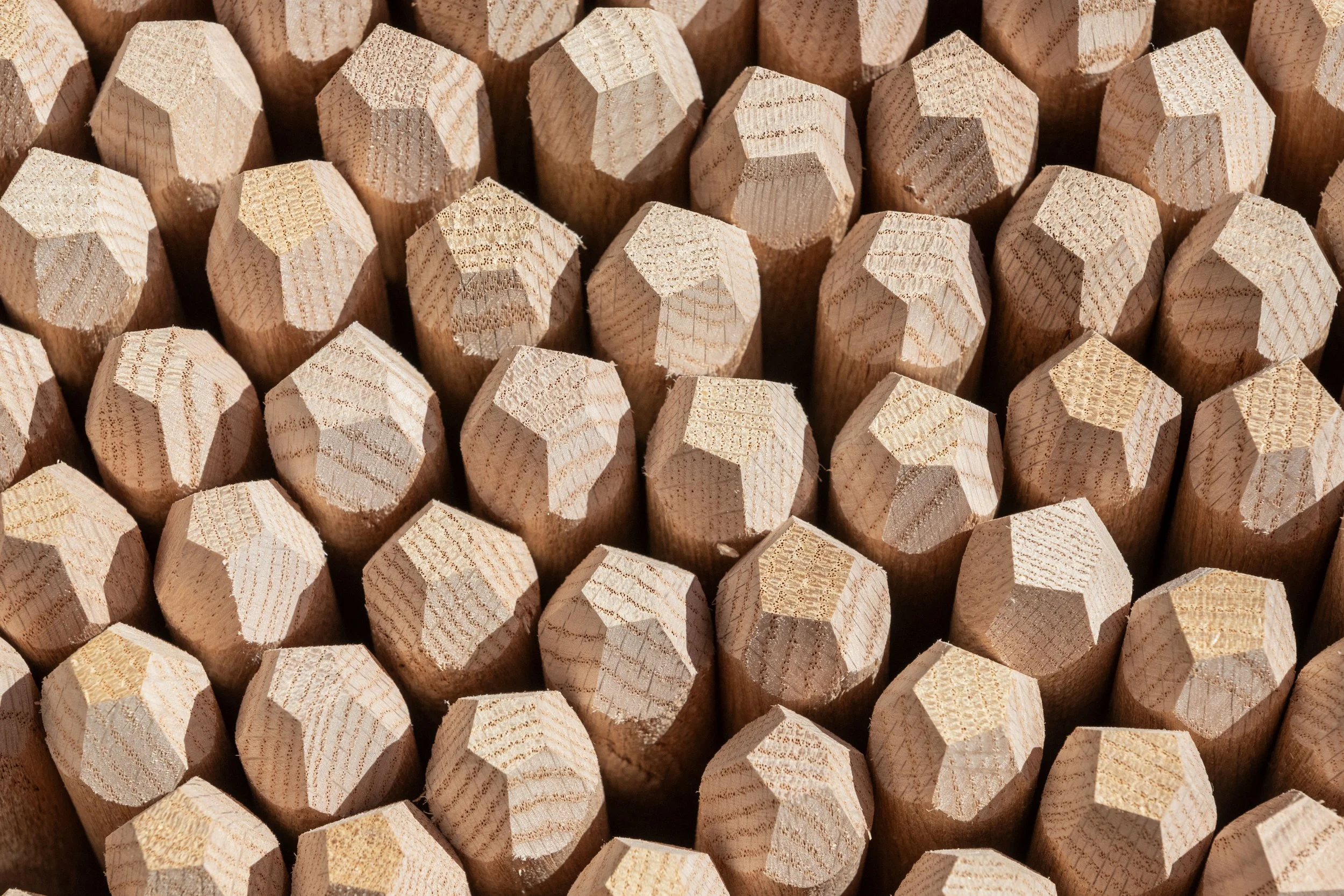 Close-up view of multiple sharpened wooden pencils with hexagonal shapes, arranged tightly together.