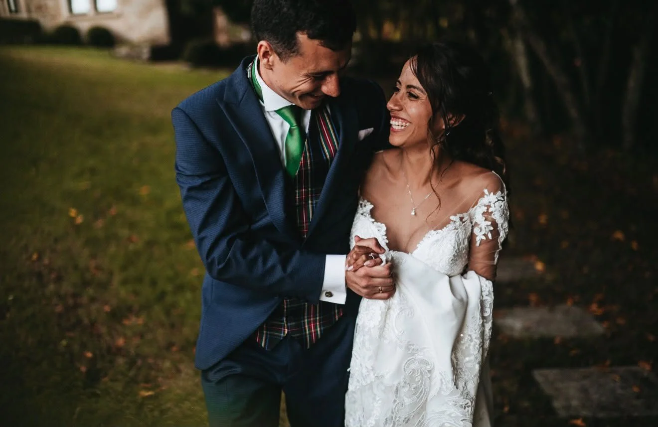 Pareja de recién casados riendo y caminando y riendo juntos durante el atardecer.