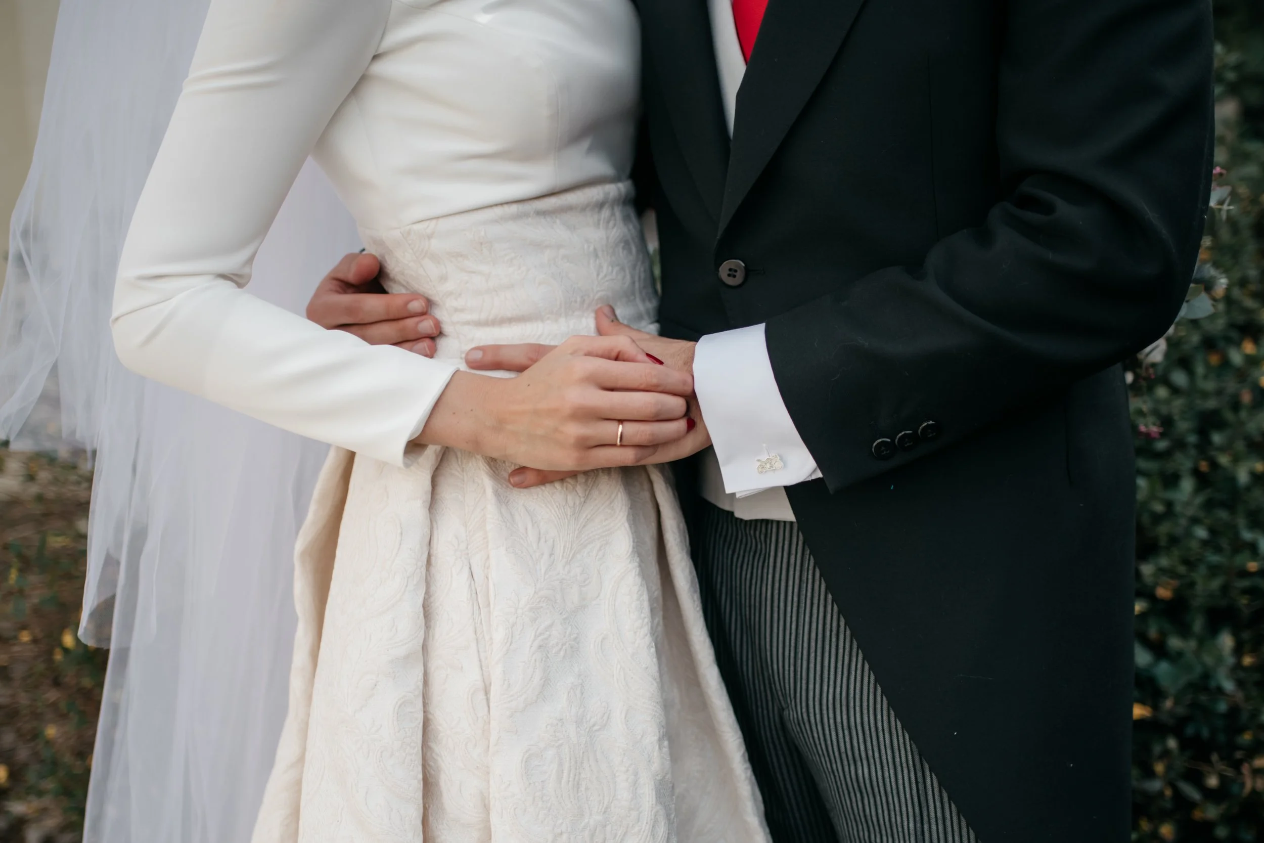 Novia y novio cogidos de la mano en el reportaje fotográfico de su boda.