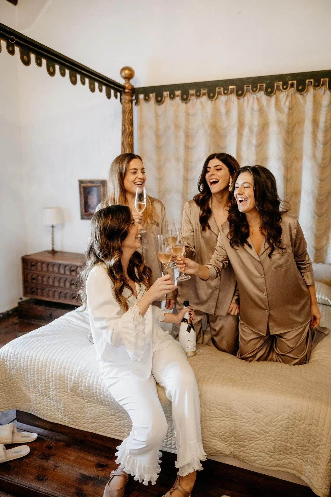 La novia y sus amigas en pijama brindando en la suite durante los preparativos de la boda.