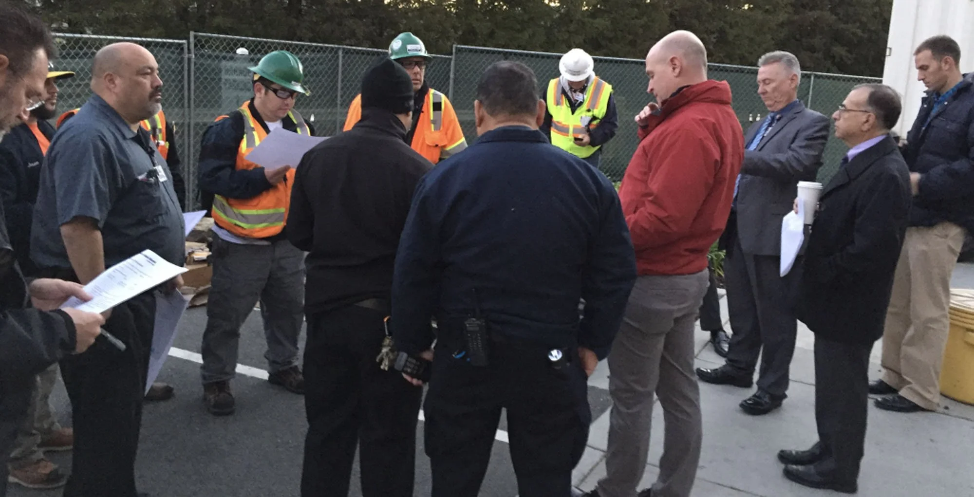 Group of men wearing safety gear in a meeting outdoors