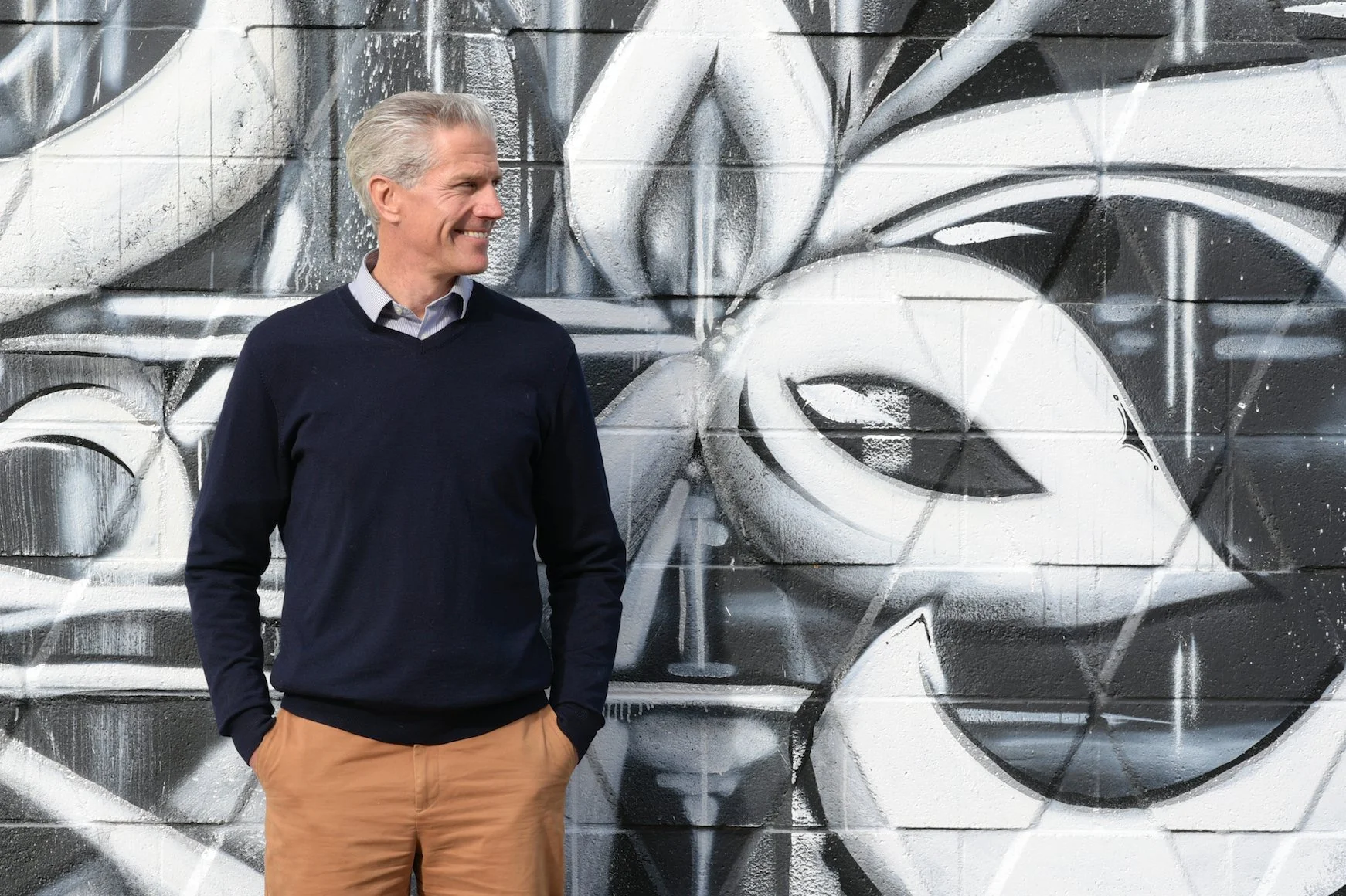 John Griffiths, Managing Principal of CONTECH-CA, standing beside a mural