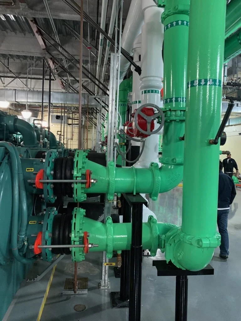 Green and white pipes in warehouse basement.