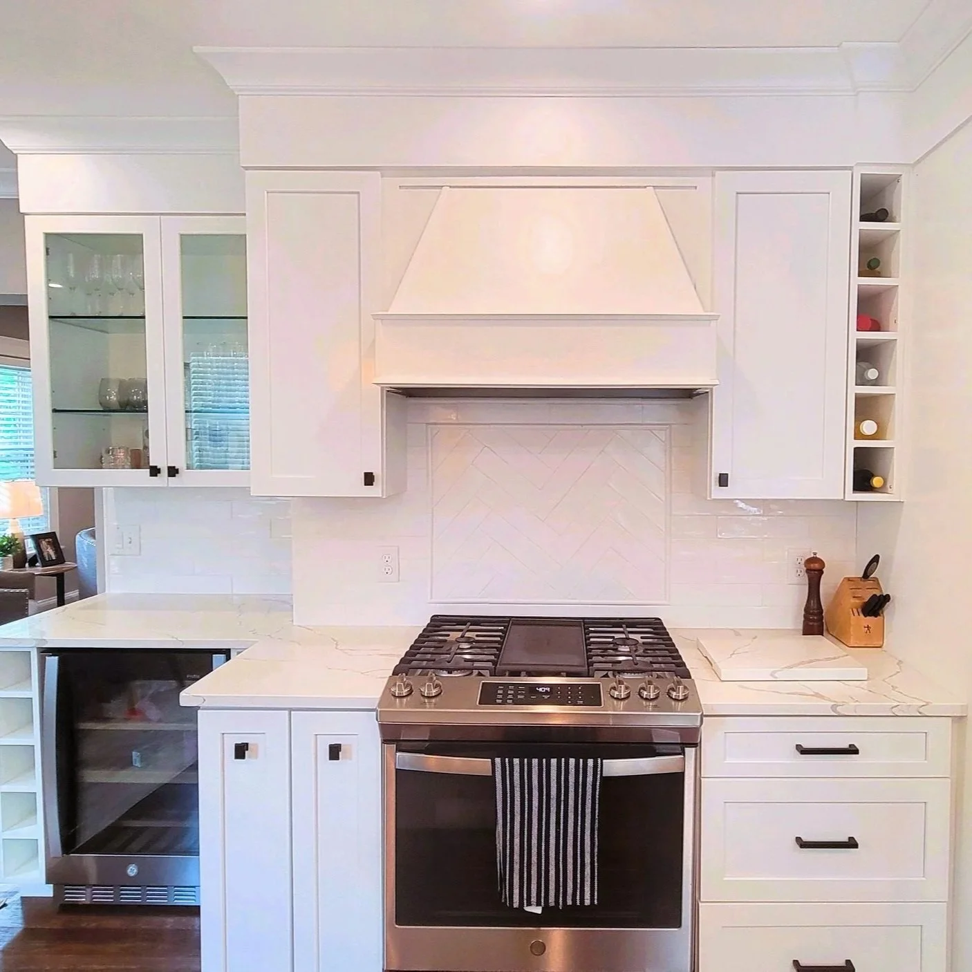White kitchen with built-in cabinets, a gas stove, and a marble countertop. Renovated Structure Pro in Massachusetts