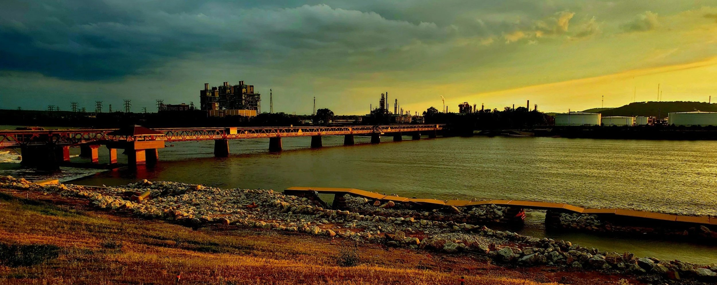 The Arkansas River at sunset (a particularly green sunset) with a view of the Pedestrian Bridge.