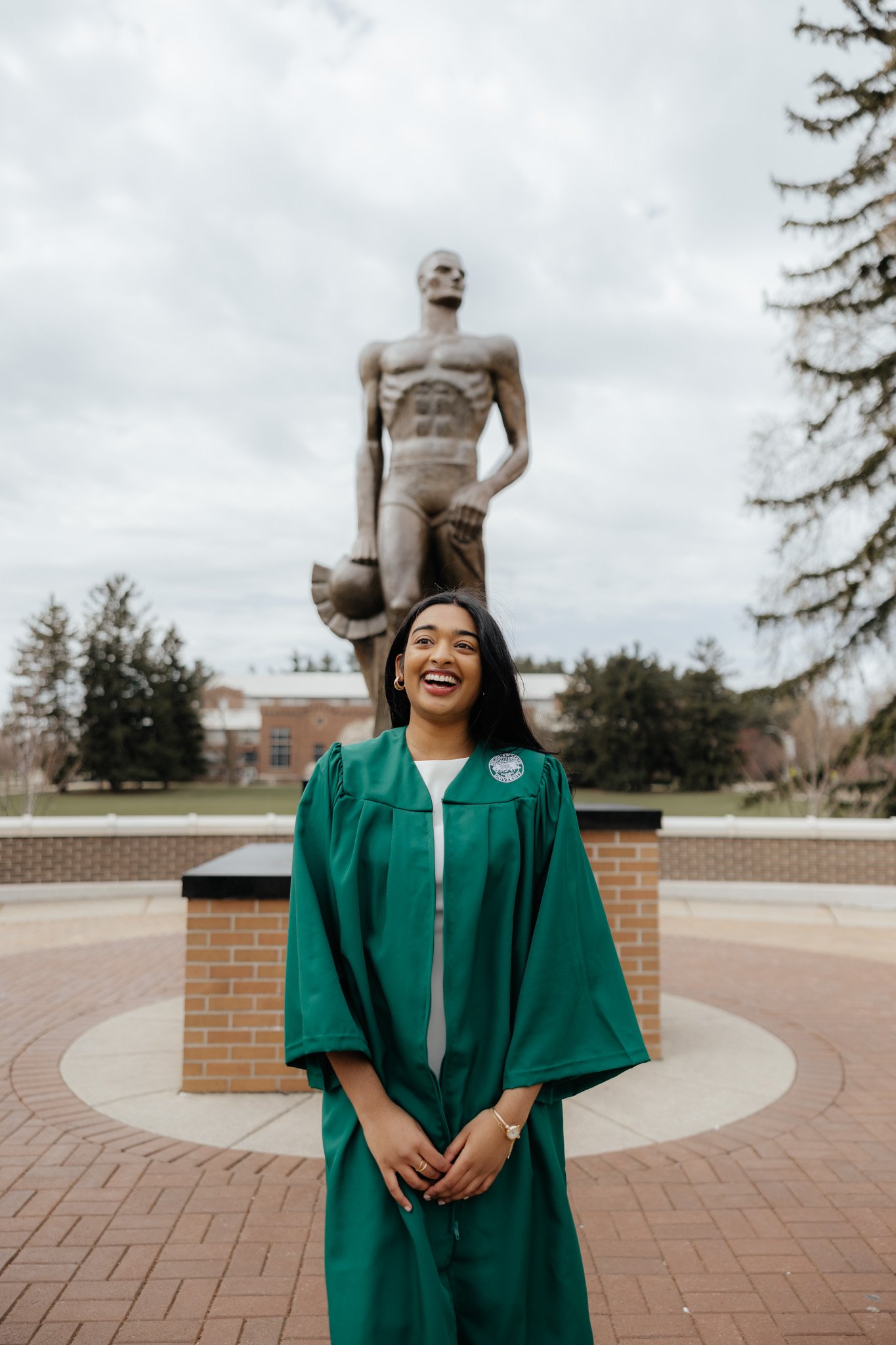Michigan State University graduation photos, Sparty statue cap and gown, green gown for graduate, celebration and candid.