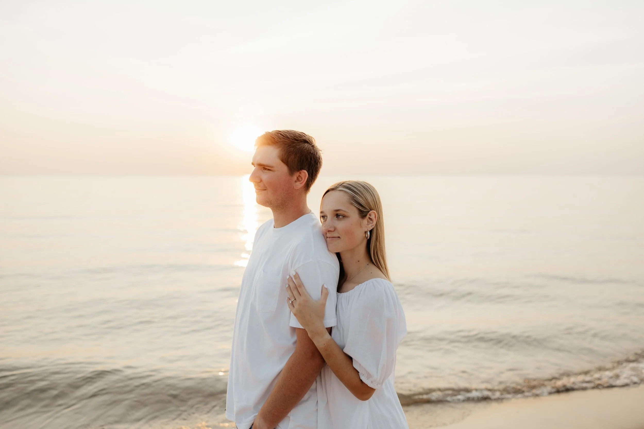 Couples engagement session at the beach of Lake Michigan during a summer golden hour.