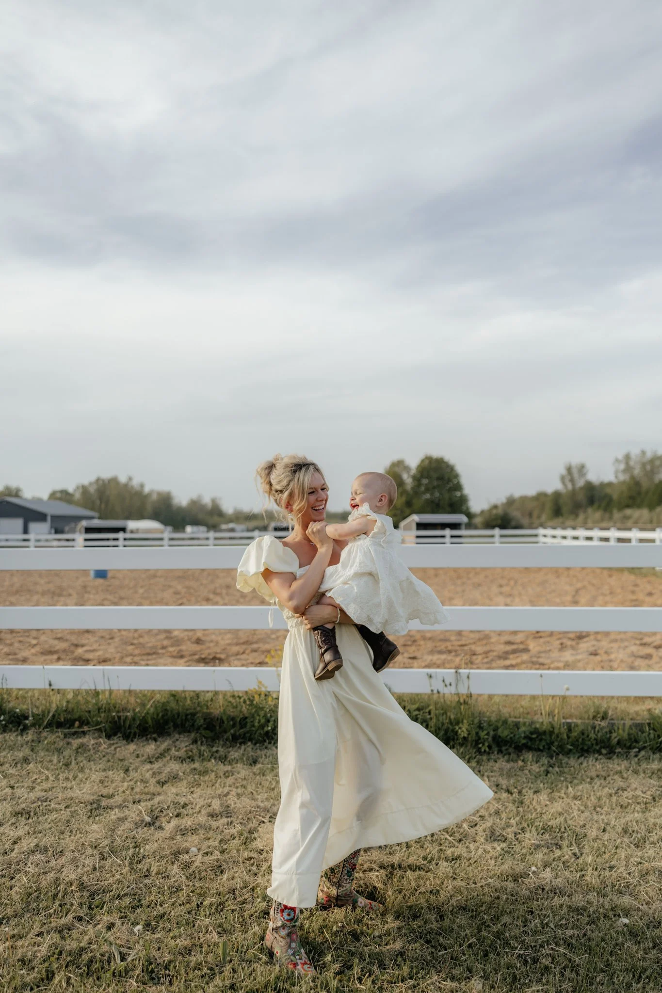 Family mom and child playing during session laughing and in the moment on a farm in Holland, Michigan with horses.
