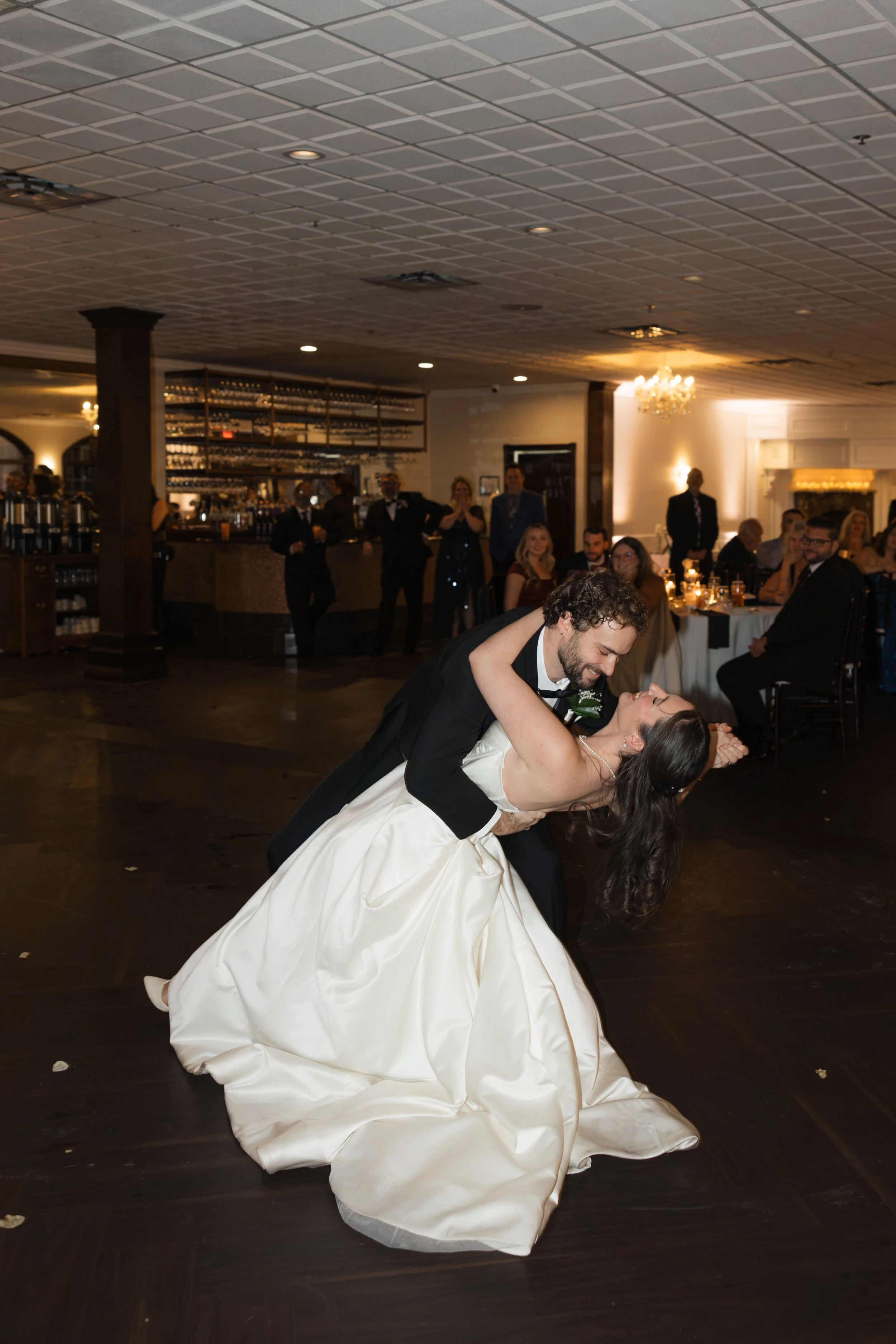 A newlywed couple dancing at their winter wedding reception at The Captains Club in Grand Blanc, Michigan. A choreographed wedding first dance at indoor moody venue.