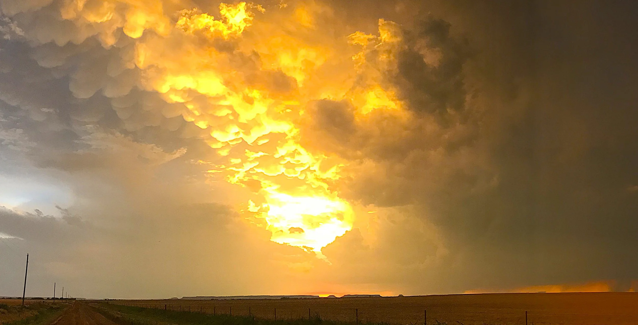 Sunlight filtering through mammatus clouds, revealing order and resonance with AUM, Mother Nature, Music, and Light Energy within atmospheric complexity