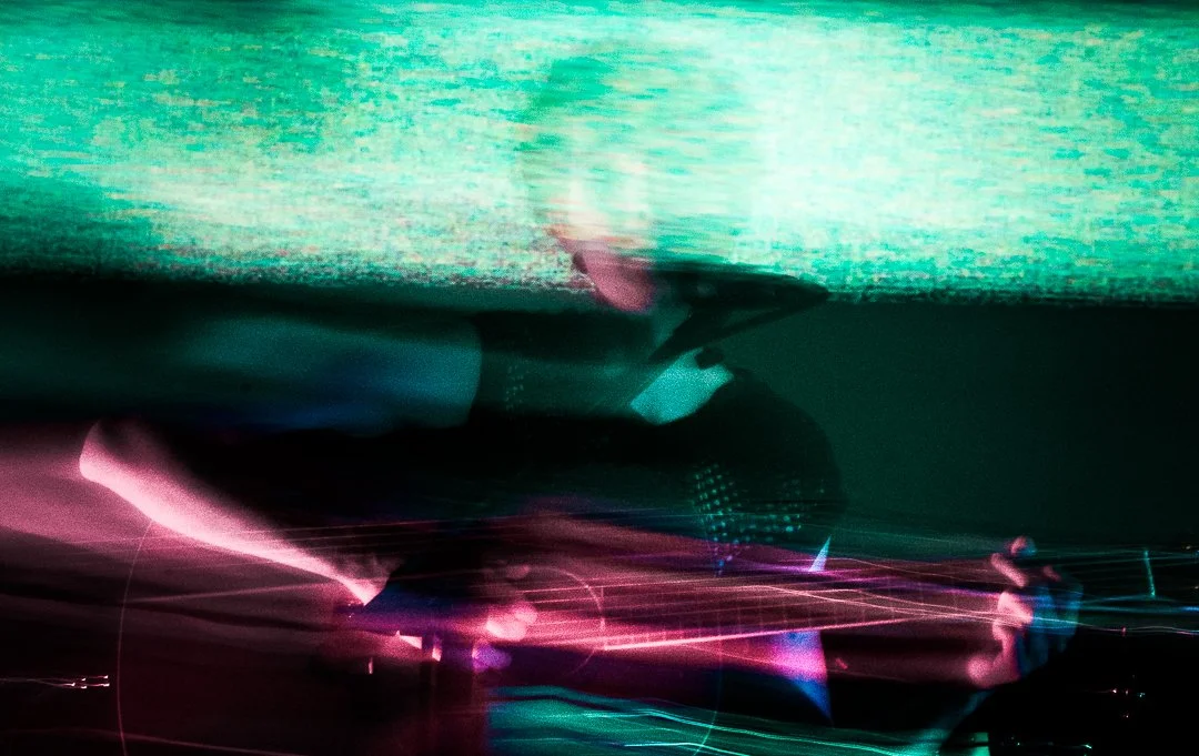 Abstract photo of a person with blurry, colorful lights and digital effects, making the person almost unrecognizable.