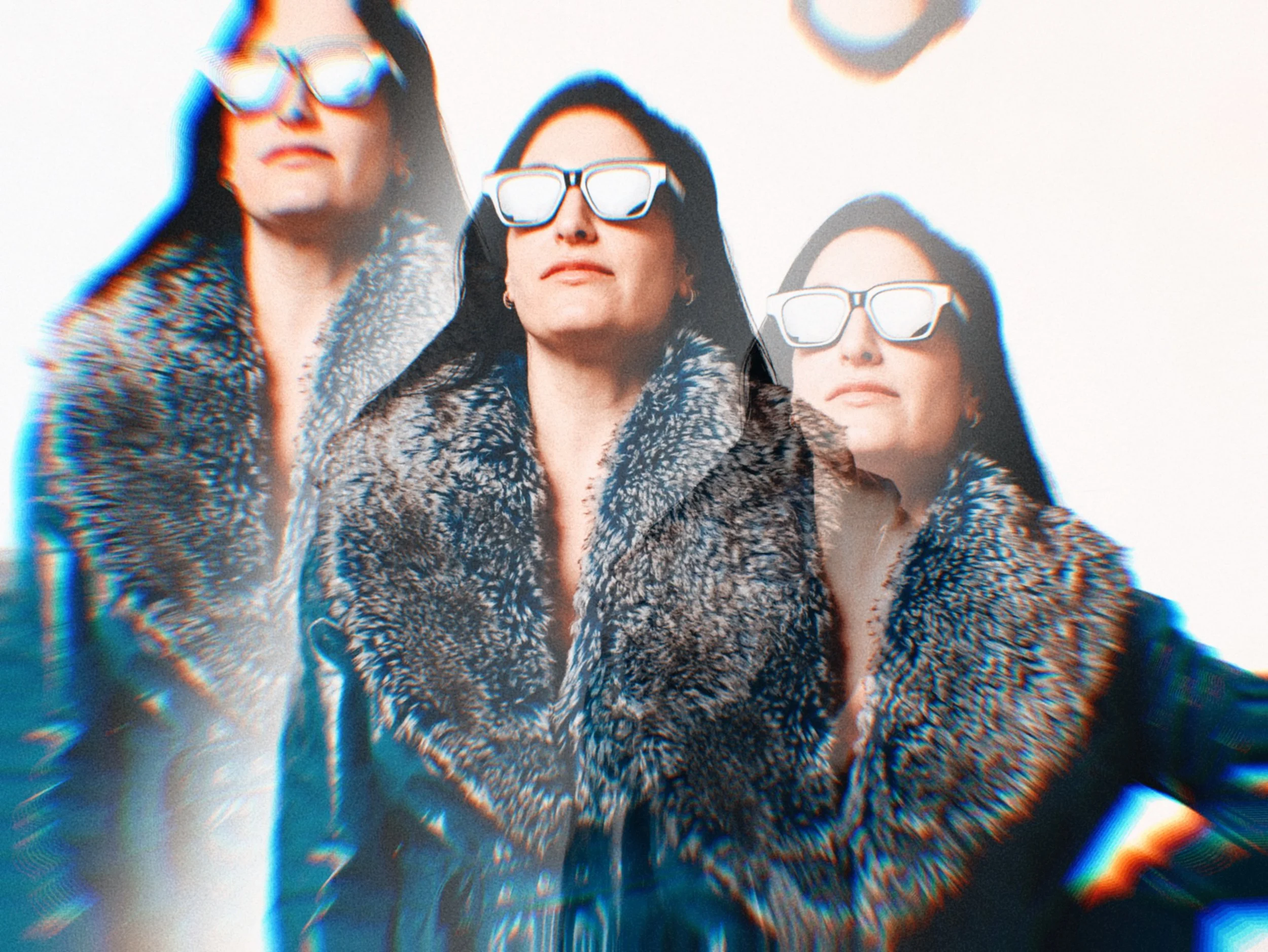 One women with dark hair wearing large sunglasses and patterned jackets looking upward. The photo has a glitch effect with rainbow colors and a circular distortion.