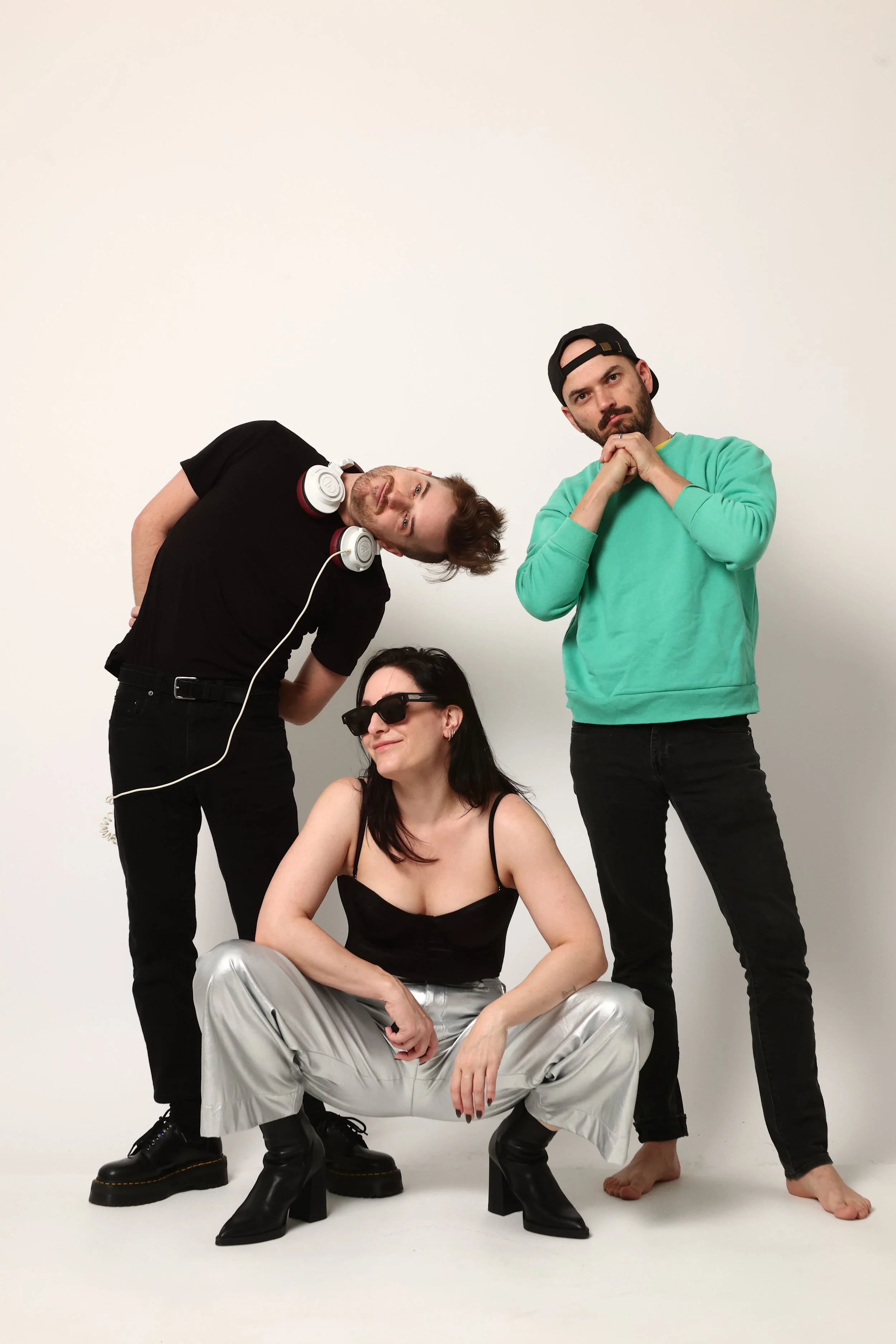 The three band members posing candidly against a plain white background.