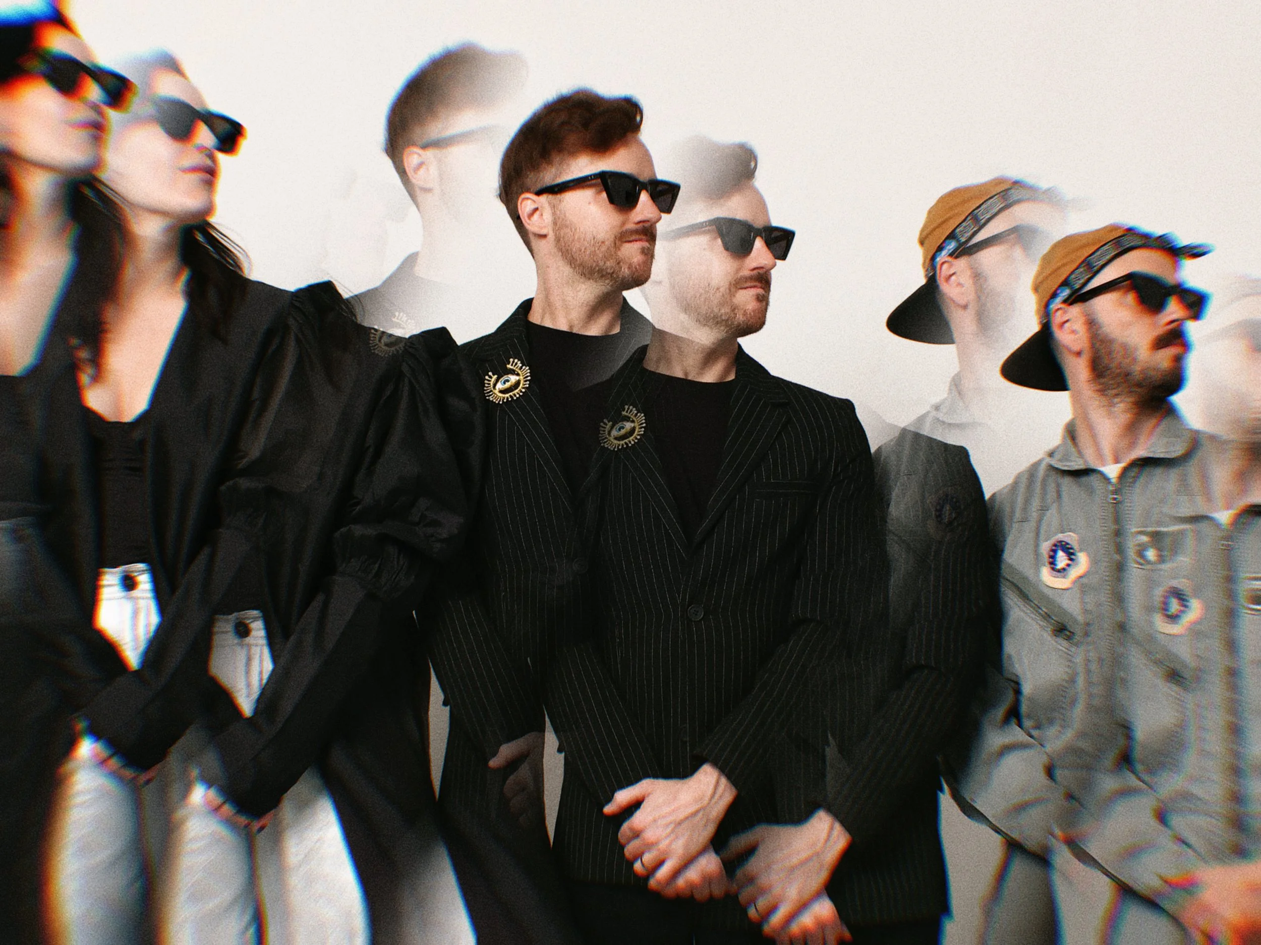 The band, all wearing sunglasses, standing in a row against a plain white background. They are looking in the same direction, with serious expressions, and are dressed in dark and casual clothing. The image features a kaleidoscopic repetitive effect.