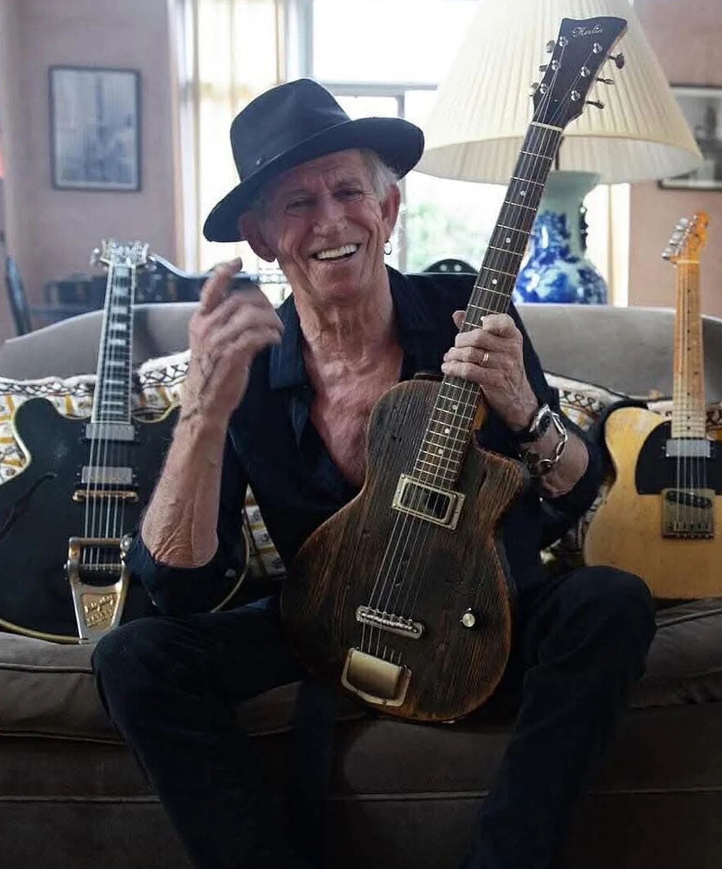 Keith Richards holding his Herlin guitar named Black Pearl, handcrafted in Stockholm, inspired by acoustic blues, Hawaiian jazz and fingerstyle traditions