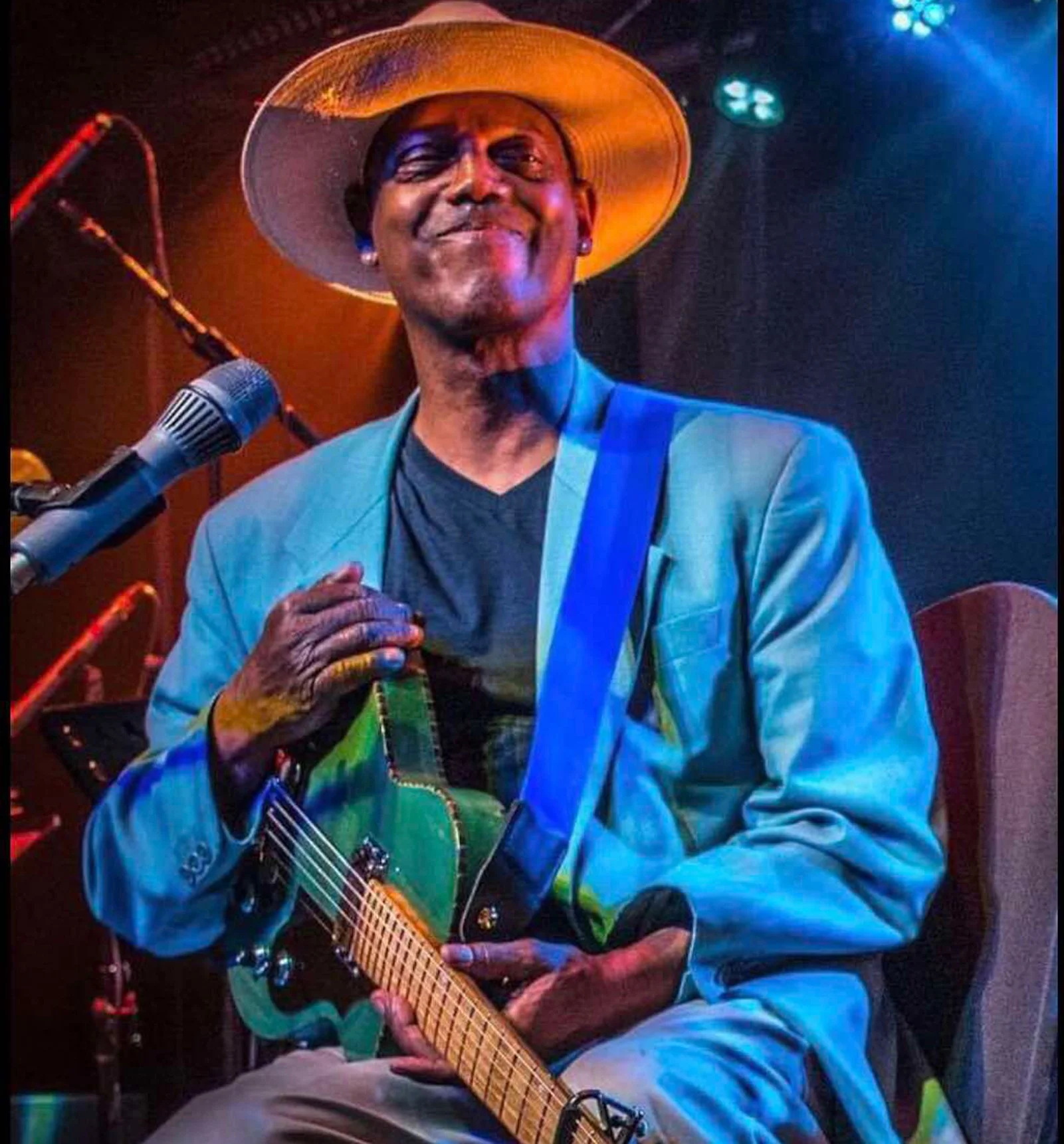 Eric Bibb with his handcrafted guitar in Scandinavian woods with allmoge‑craft details, earthy colours and Hawaiian‑inspired rope binding