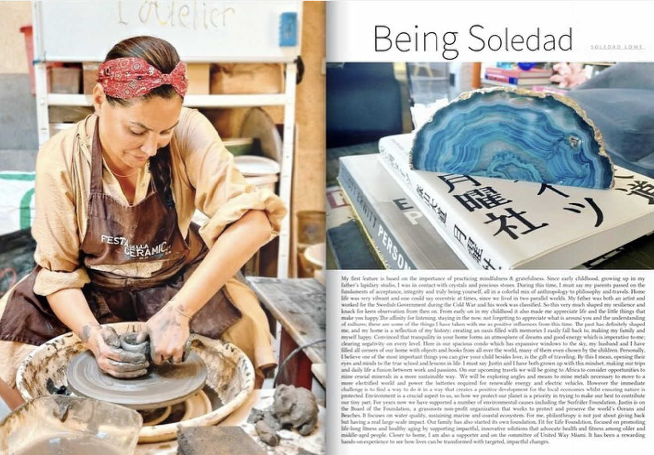 A woman with a red bandana on her hair are working at a potter's wheel, shaping clay in a ceramics studio.