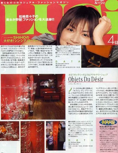 A magazine page featuring a close-up of a smiling young woman with short hair, surrounded by Japanese text, and smaller images showcasing interior decor and a jewelry display.