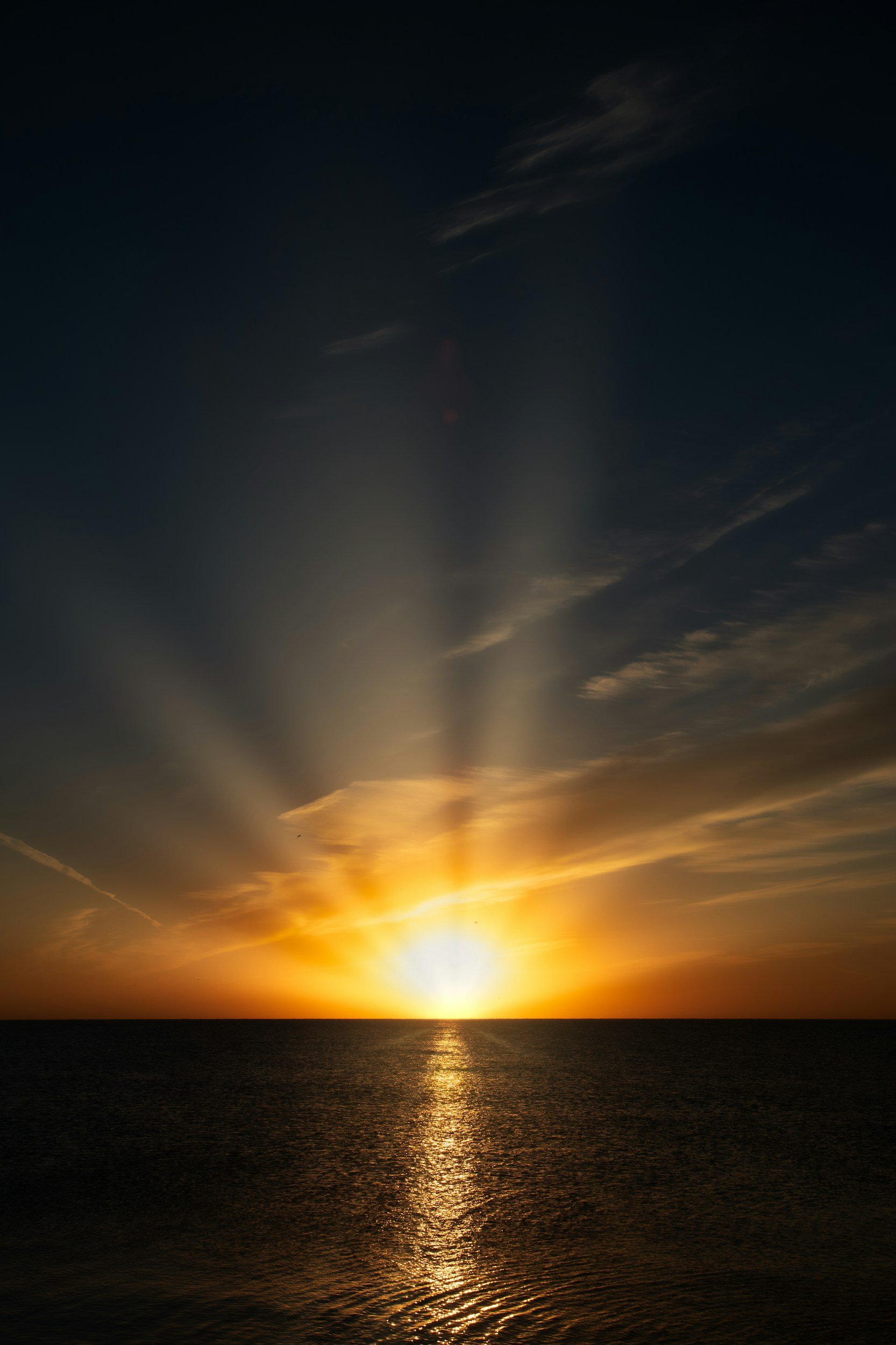 Sunset over the ocean with colorful sky and clouds.