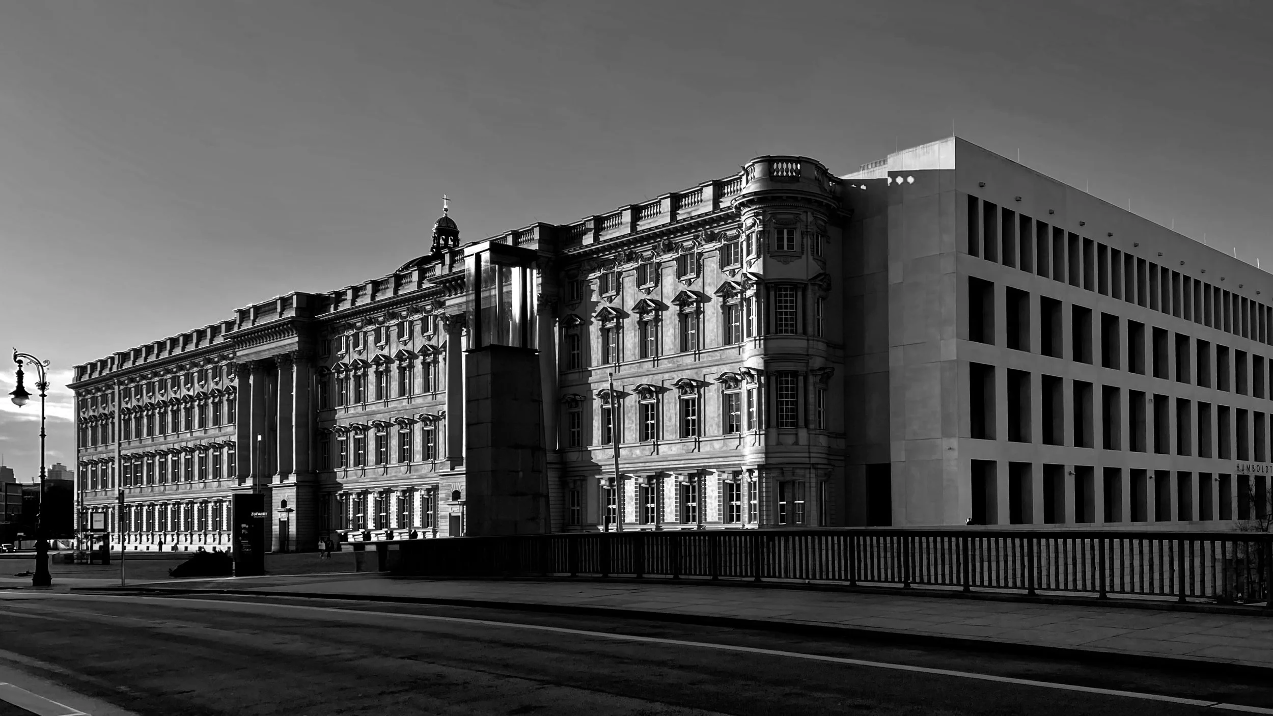 Schwarz-Weiß-Foto eines alten und eines modernen Gebäudes an einer Straße