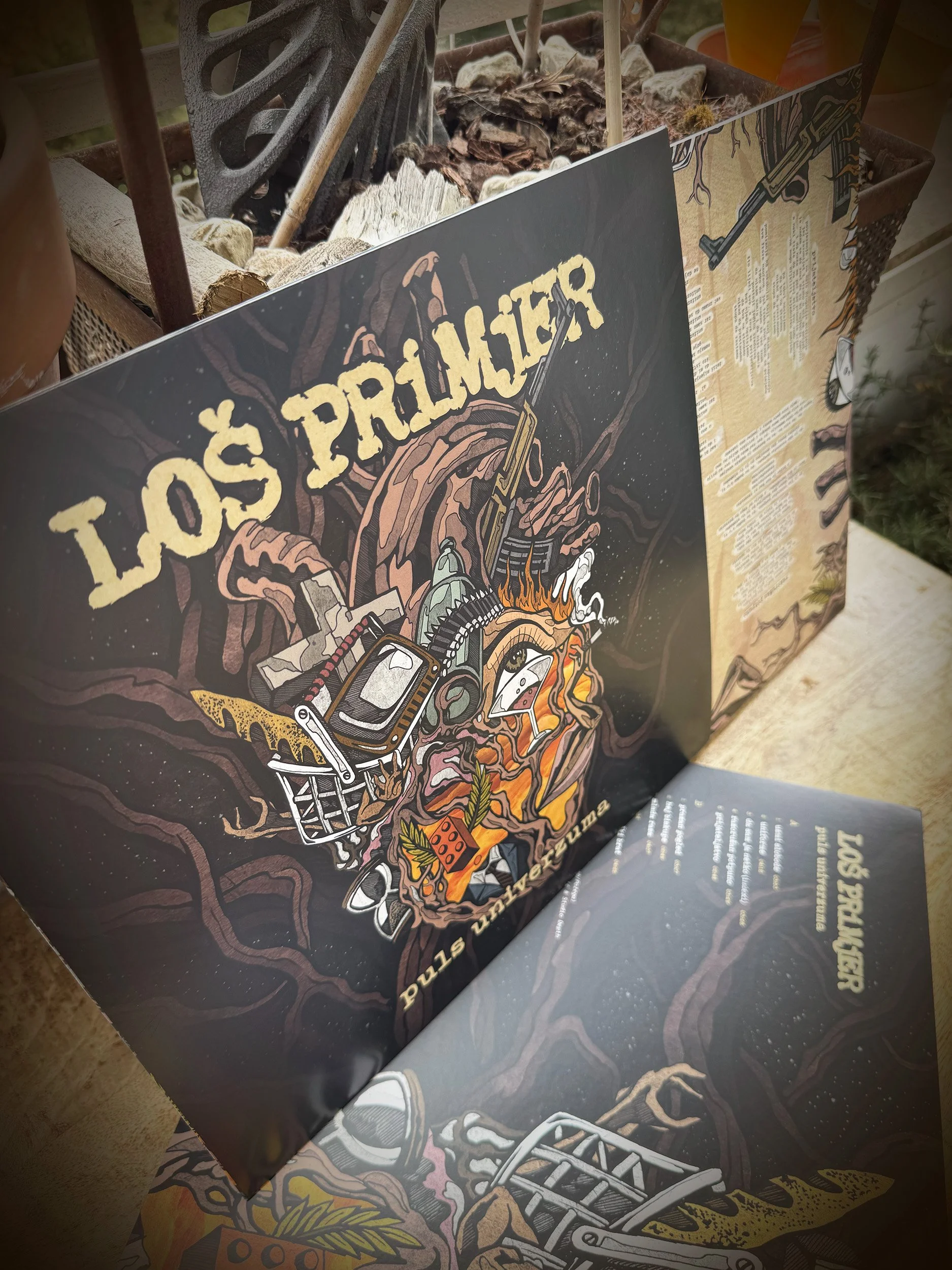 A poster with a dark background displaying the text "Lost Primer" in large, yellowish font, featuring illustrations of a chainsaw, a handgun, flames, and various mechanical and botanical elements.
