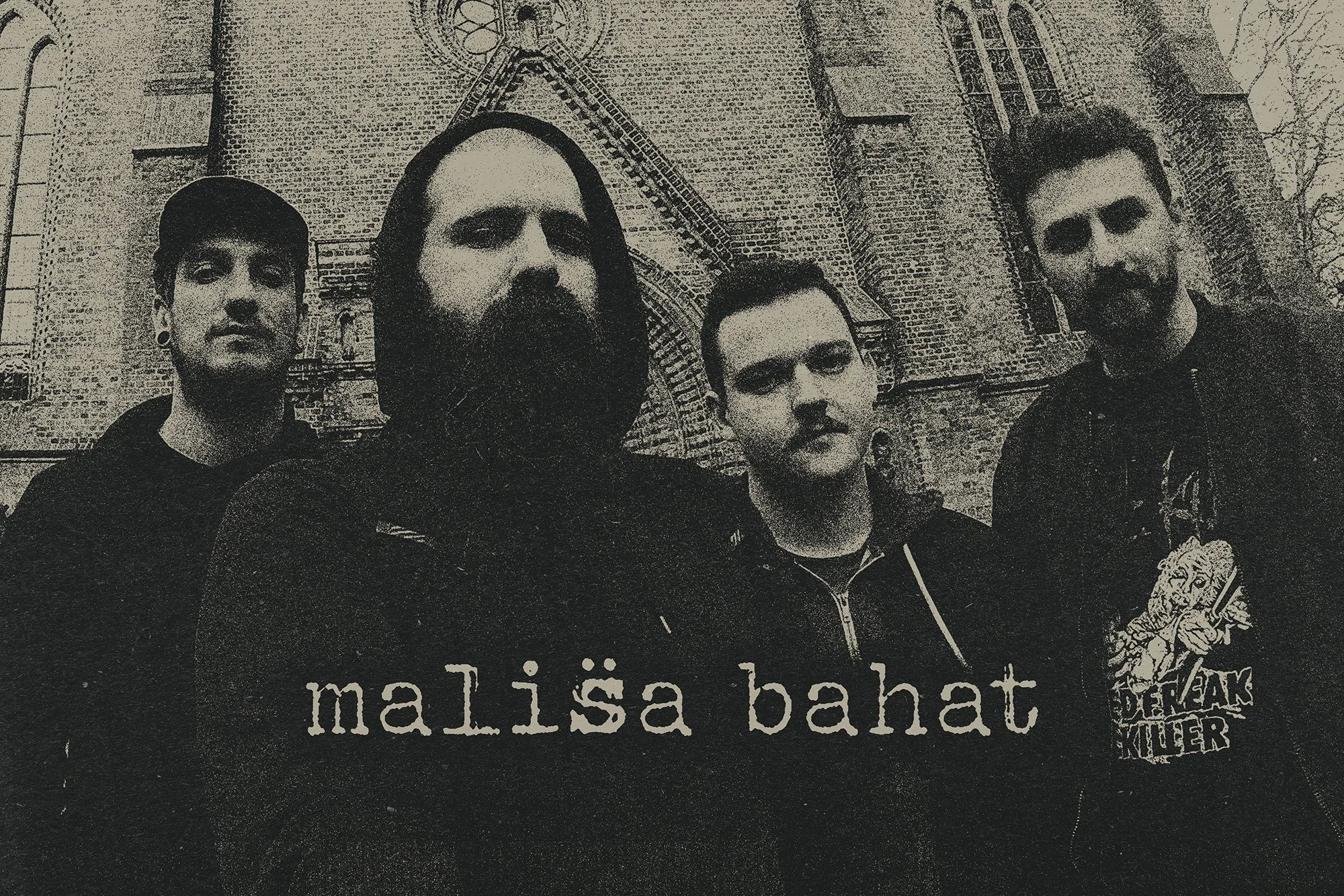 Black-and-white photo of four men standing in front of an old brick building, all band members of MALISA BAHAT screamo band.