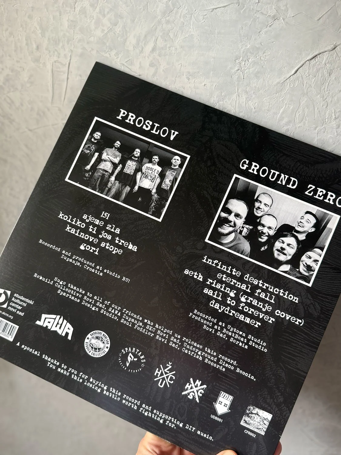 Back cover of a music album featuring two band photos, one titled "PROSLOV" and the other "GROUND ZERO." It includes song titles in Serbian and notes about recording and production, along with logos and acknowledgments at the bottom.