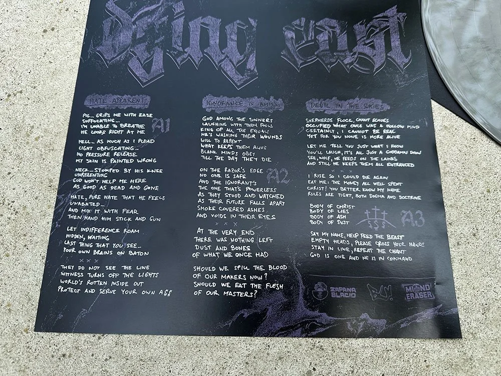 A chalkboard with lyrics from the band Dying East written on it in stylized font, surrounded by various doodles and symbols.