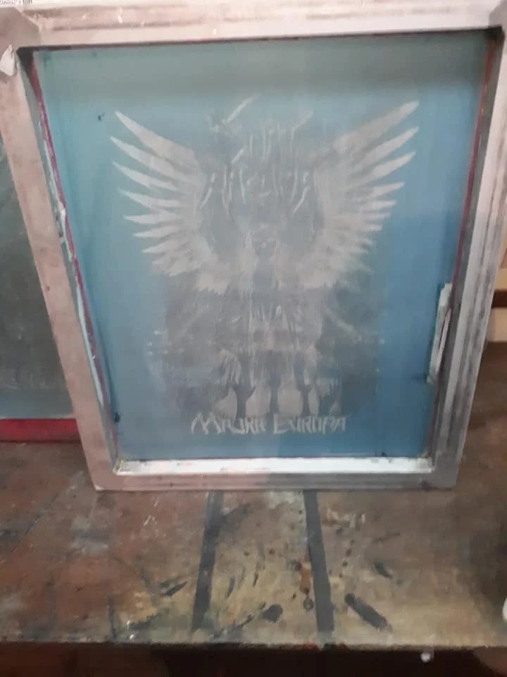 A metal screen with a painted white eagle with outstretched wings and the words "SMRT RAZUMA" underneath.